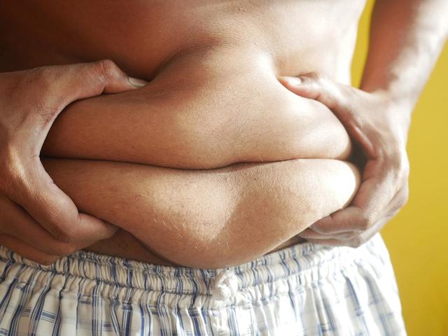 Person holding onto belly fat