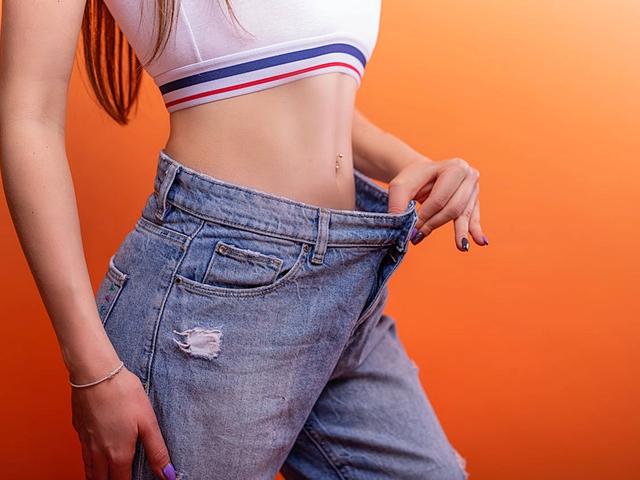 Woman showing she has lost weight