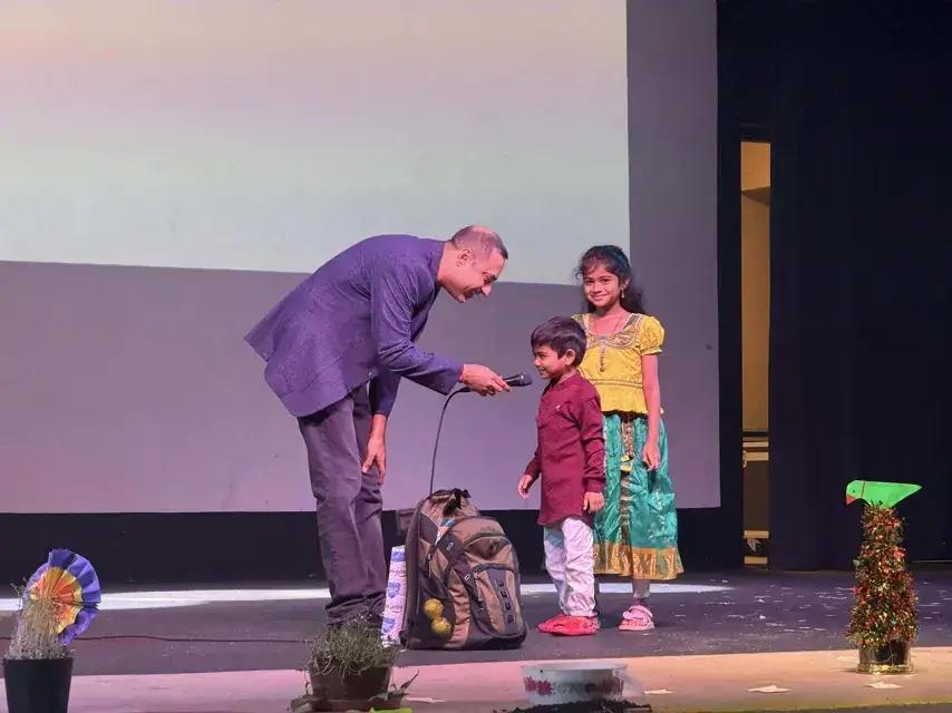Bringing two young volunteers up on stage