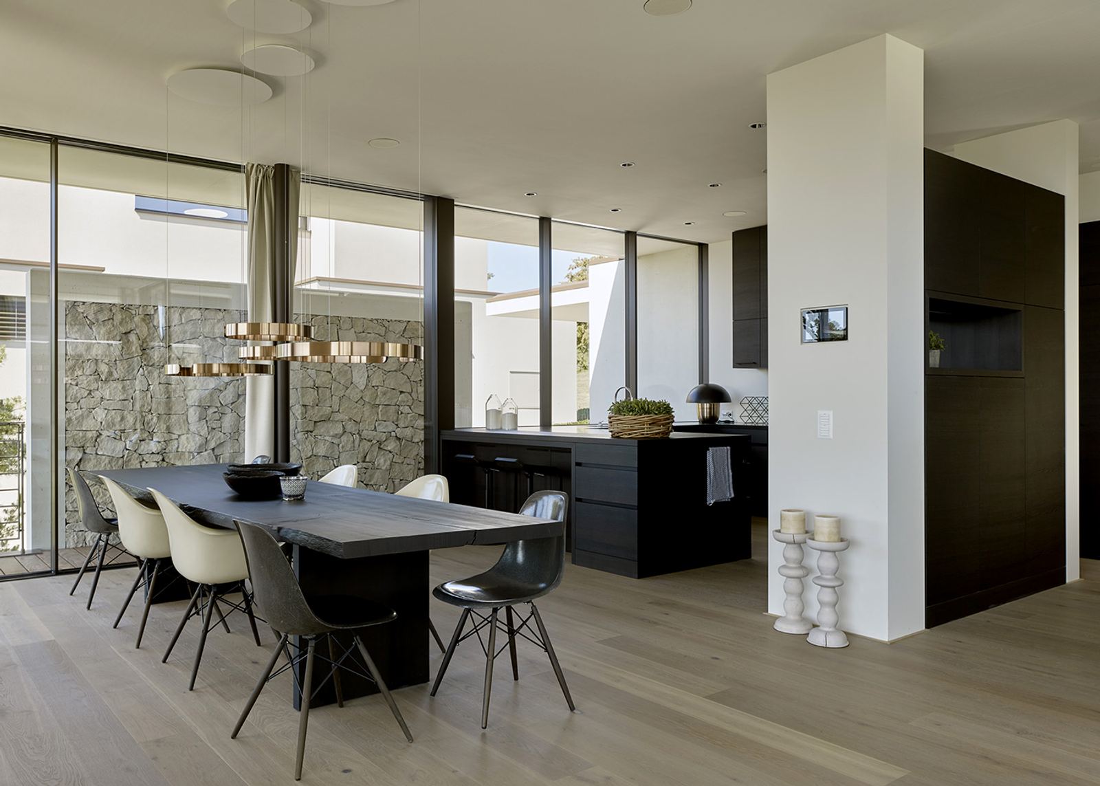 Dining area with pendant light before a dark kitchen