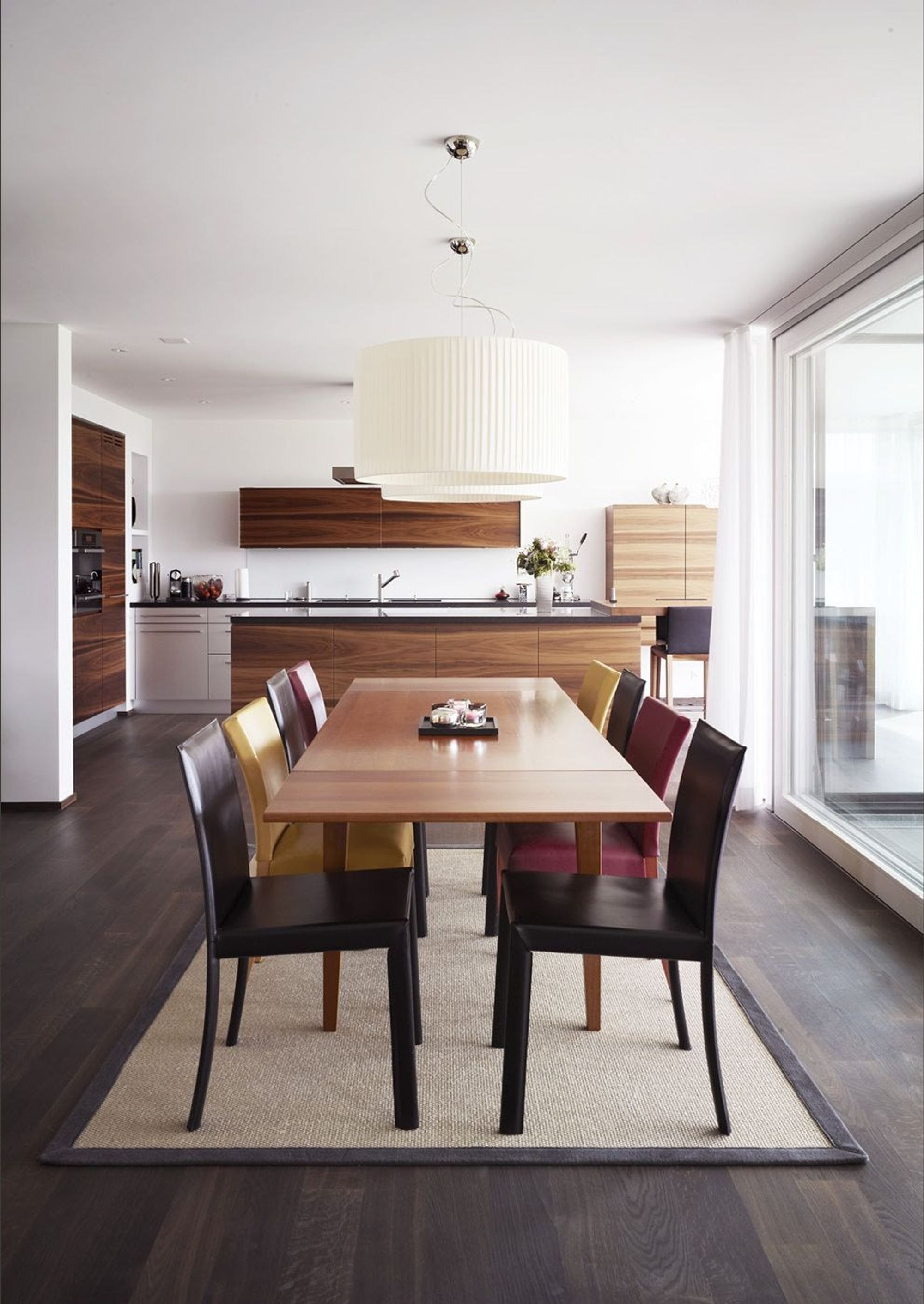 Dining table with pendant light and open kitchen – Single-family house in Russikon