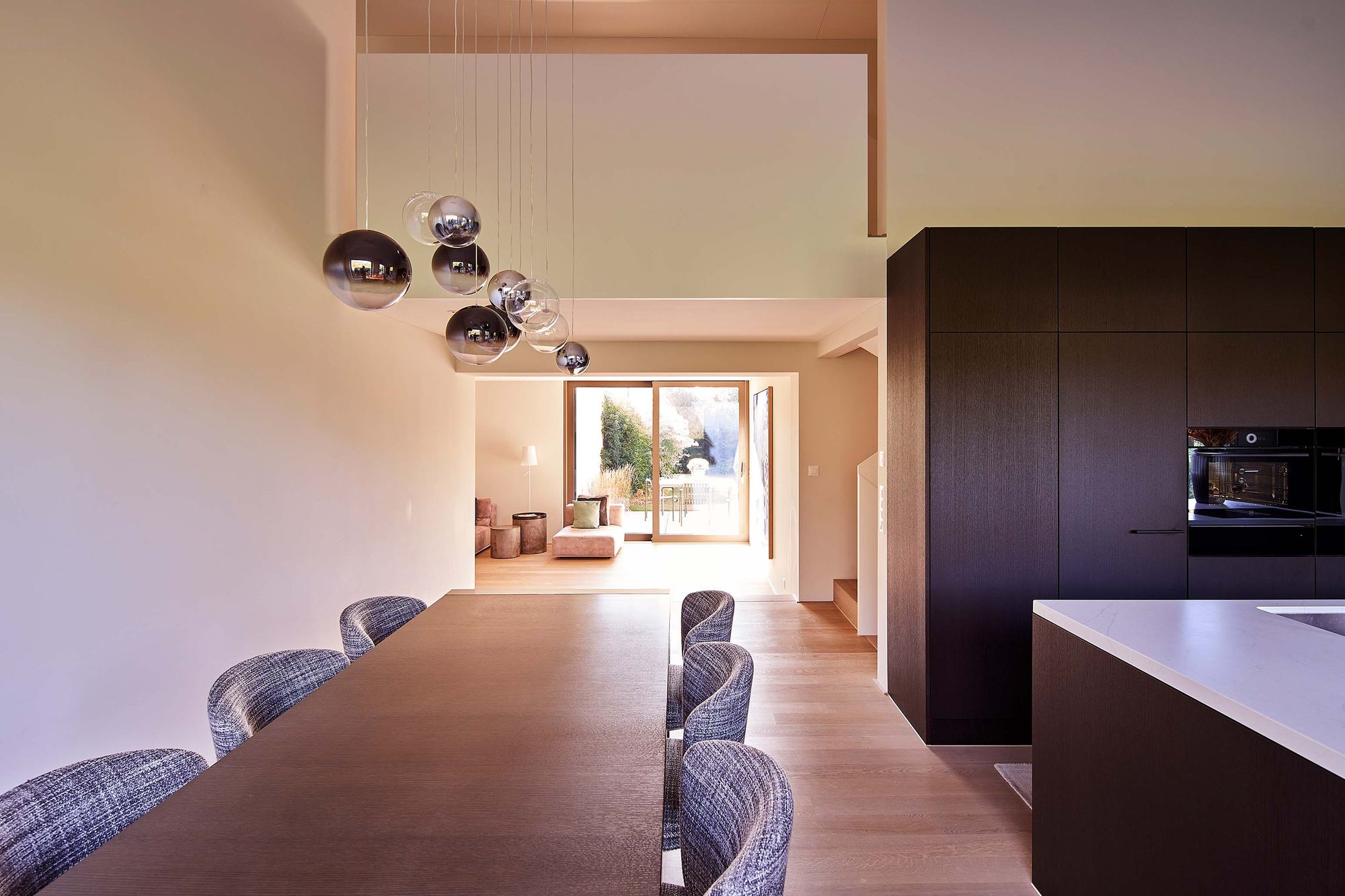 Dining table with globe pendants next to the kitchen – Interiors and landscape, Zumikon