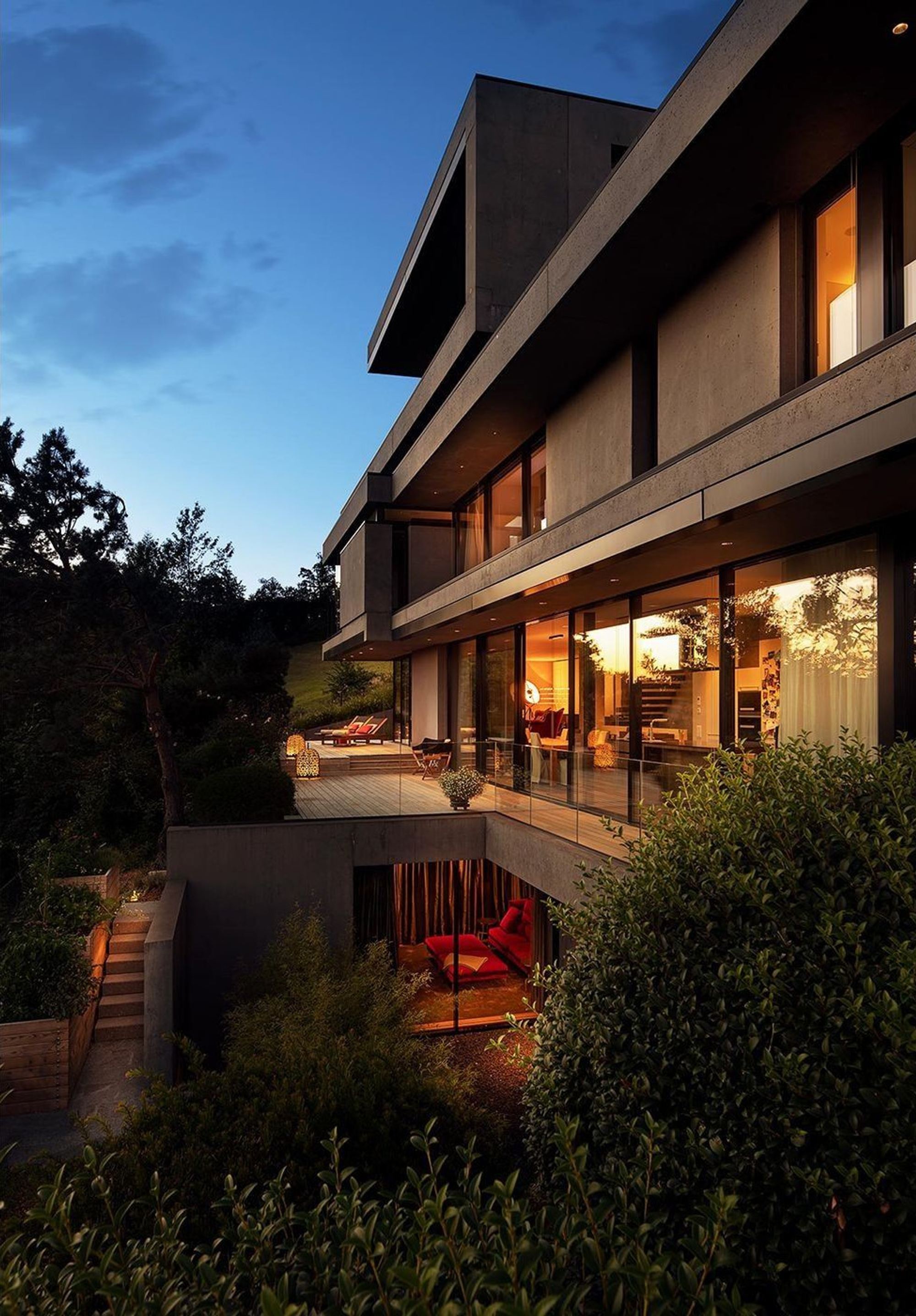 Stepped facade with balconies at dusk – Single-family house in Uitikon