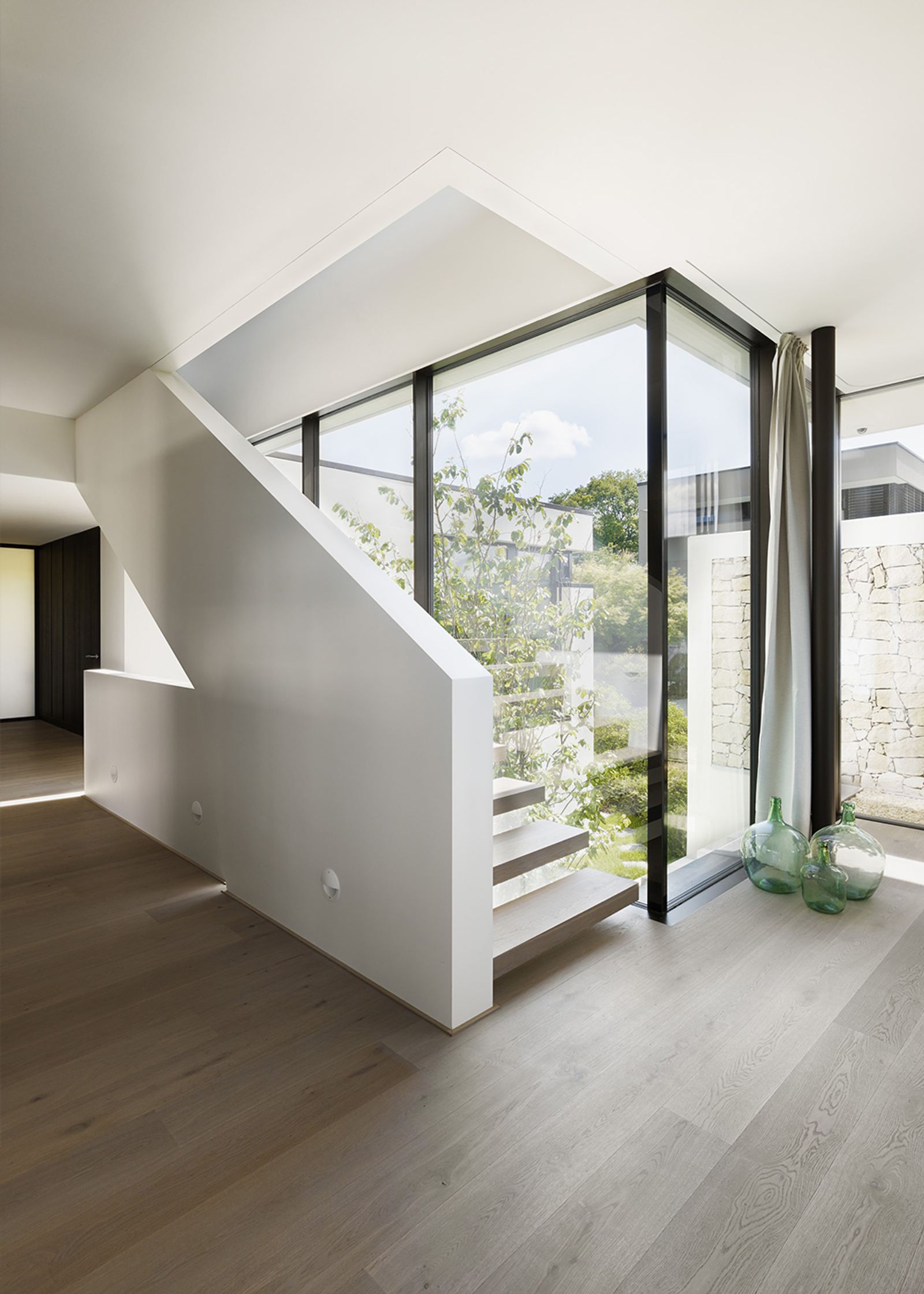 White staircase by a floor-to-ceiling window