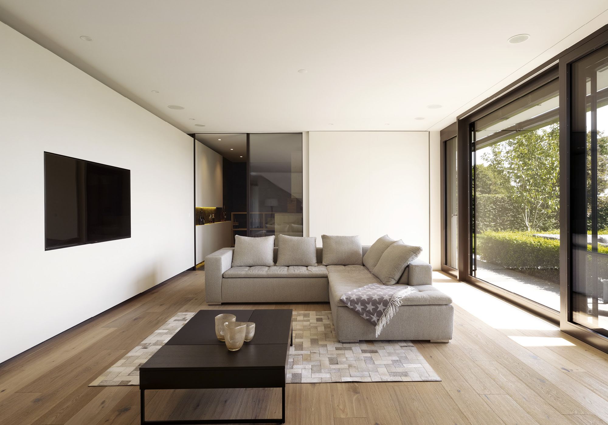 Living area with large sofa and window front – Single-family house in Oberwil-Lieli