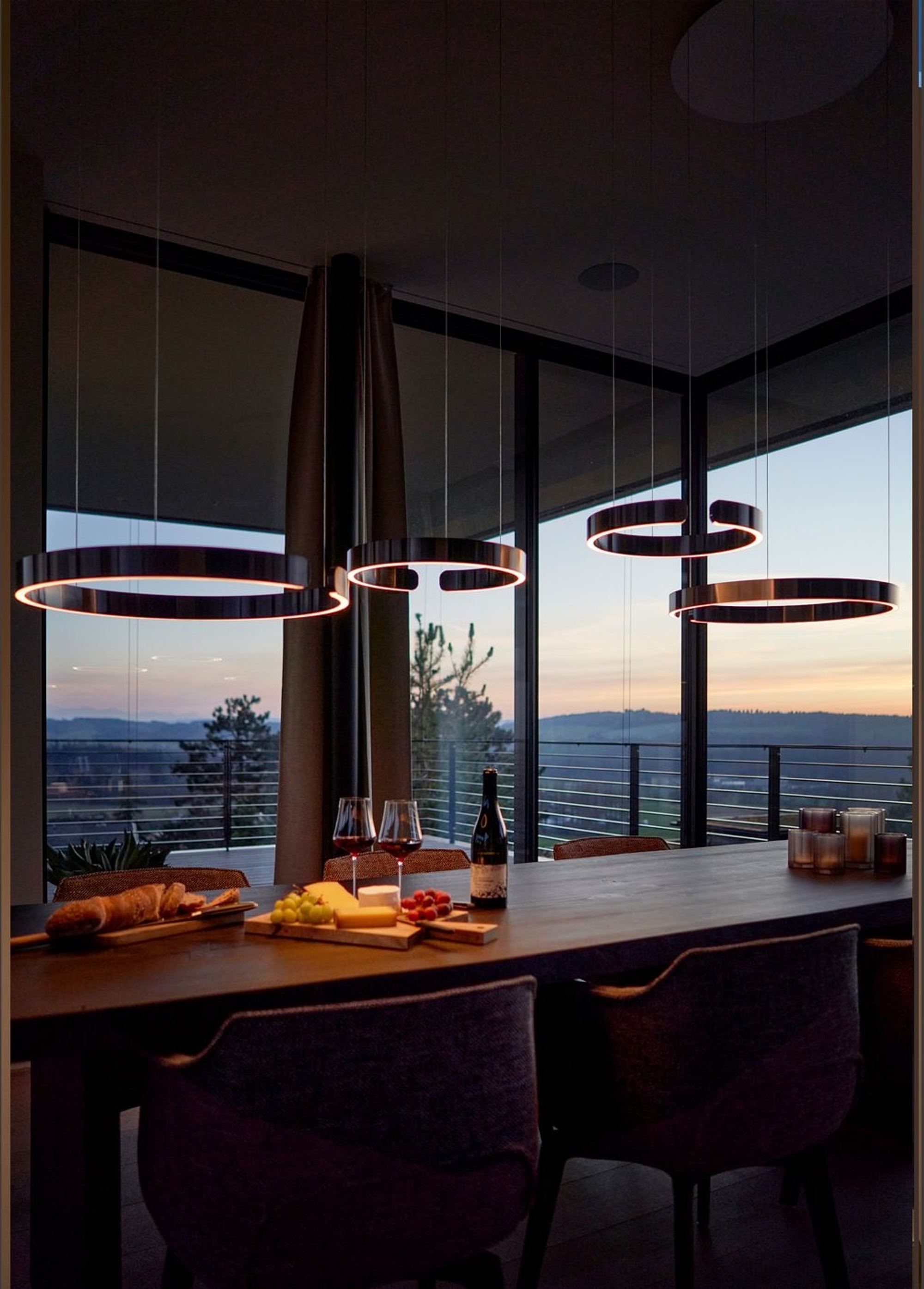 Dining table with ring pendants and open view – Single-family house in Uitikon