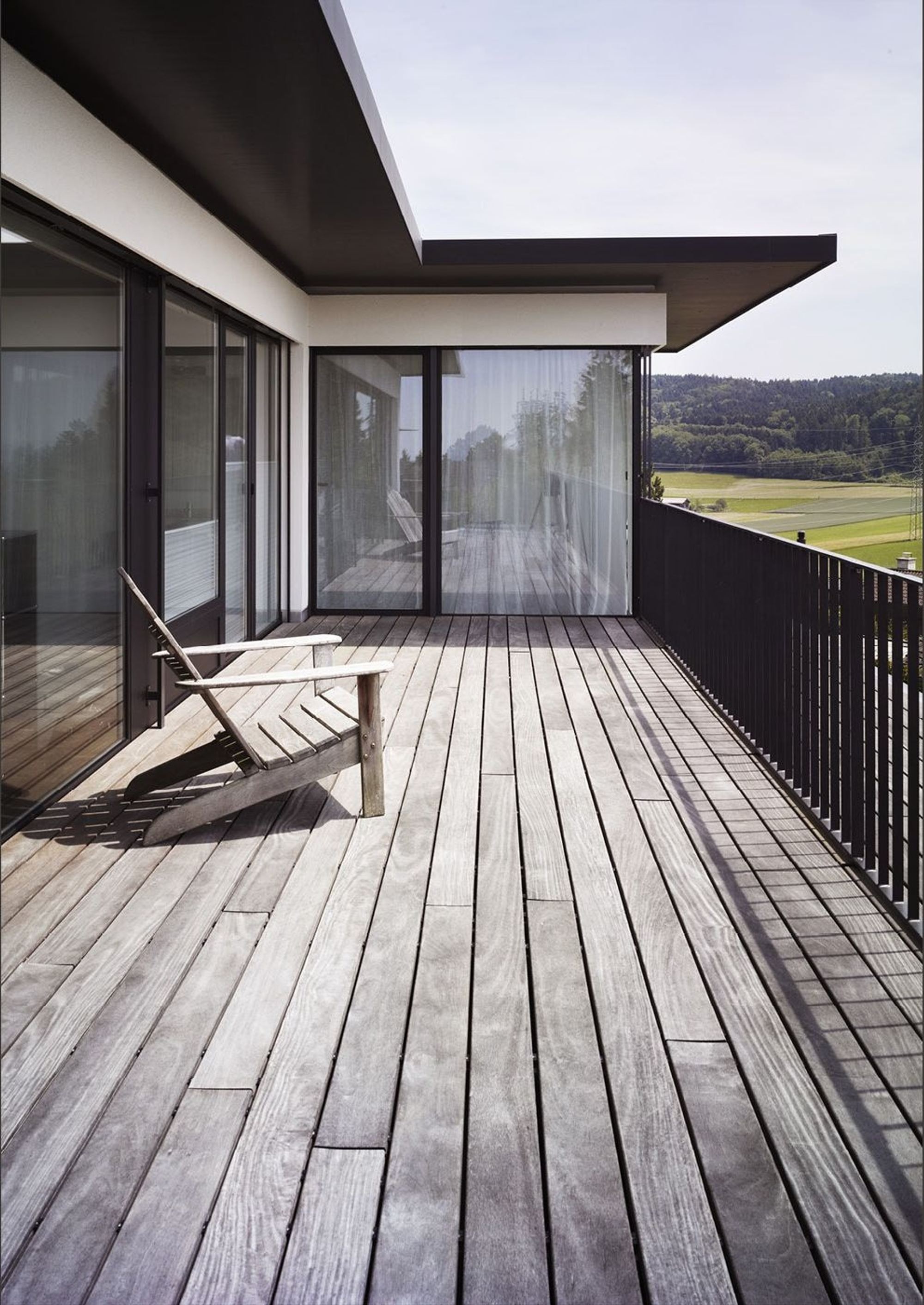 Balcony with timber floor and deckchair – Single-family house in Russikon
