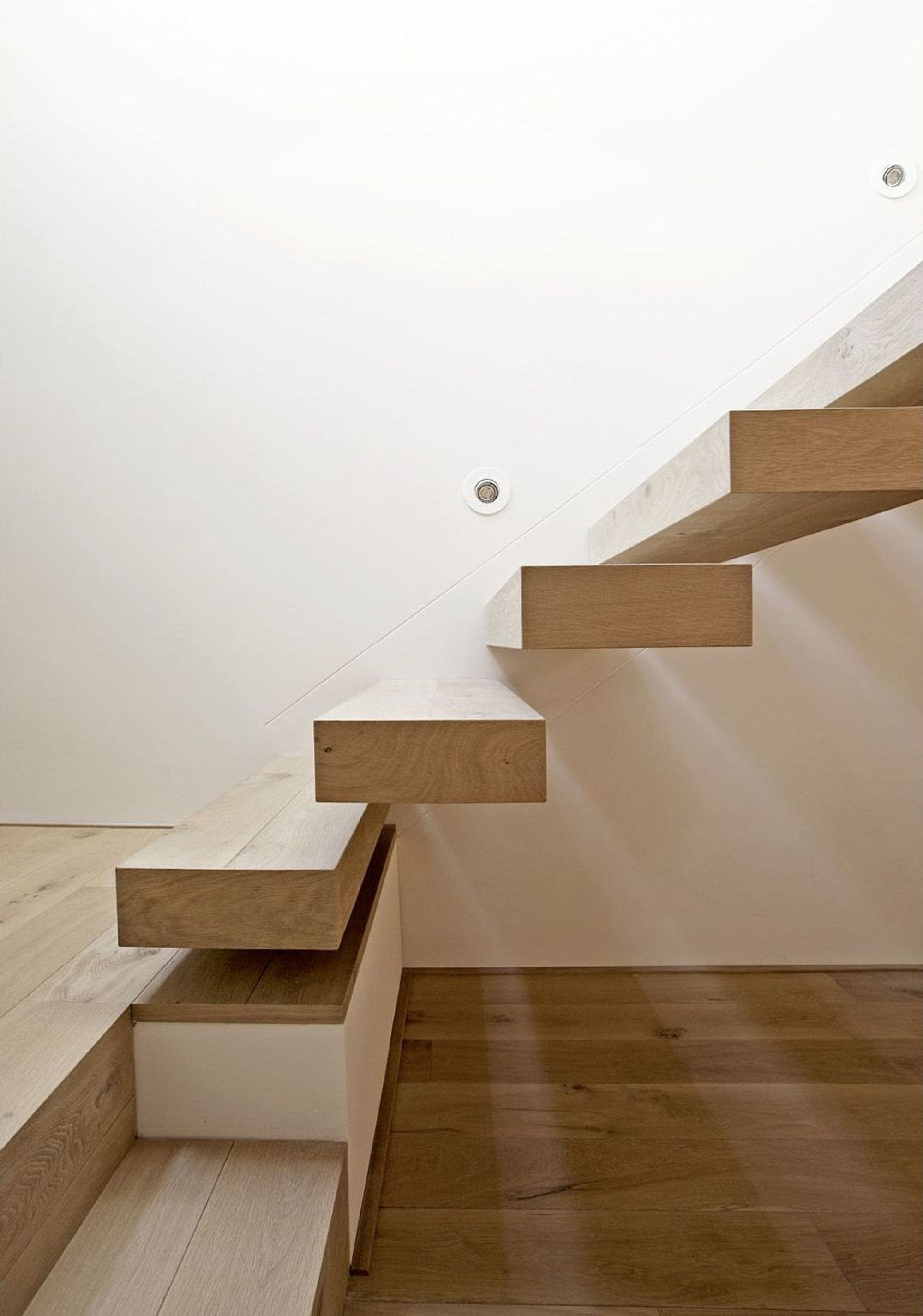 Timber staircase against a white wall – Apartment building in Uitikon