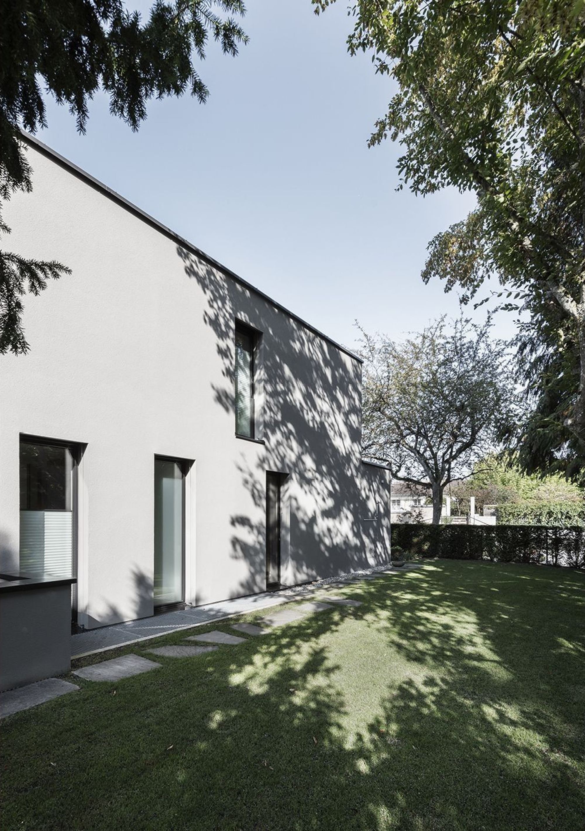 Side facade with lawn and tree shade – Single-family house in Küsnacht