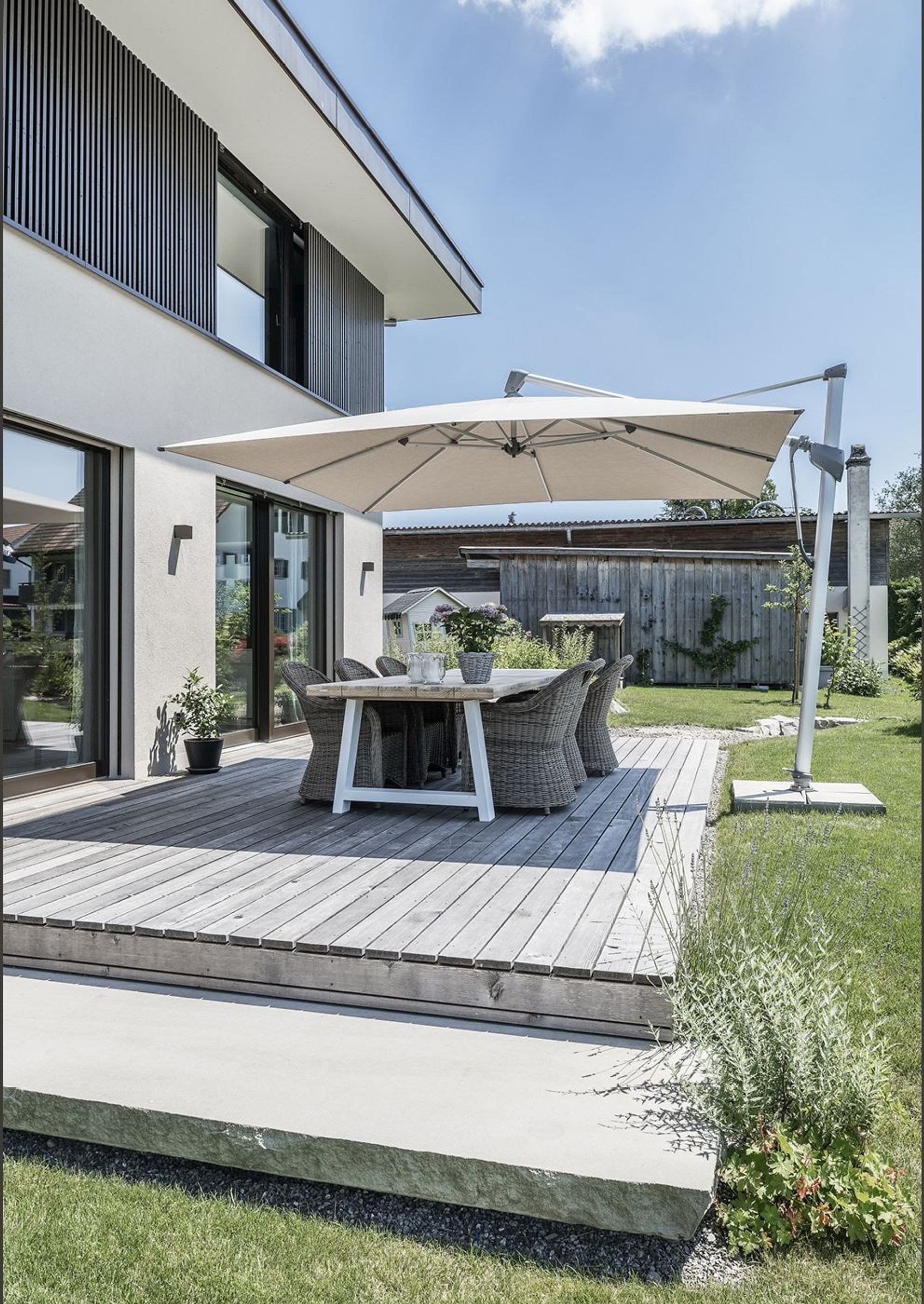 Timber terrace with dining table and parasol – Single-family house in Grüningen