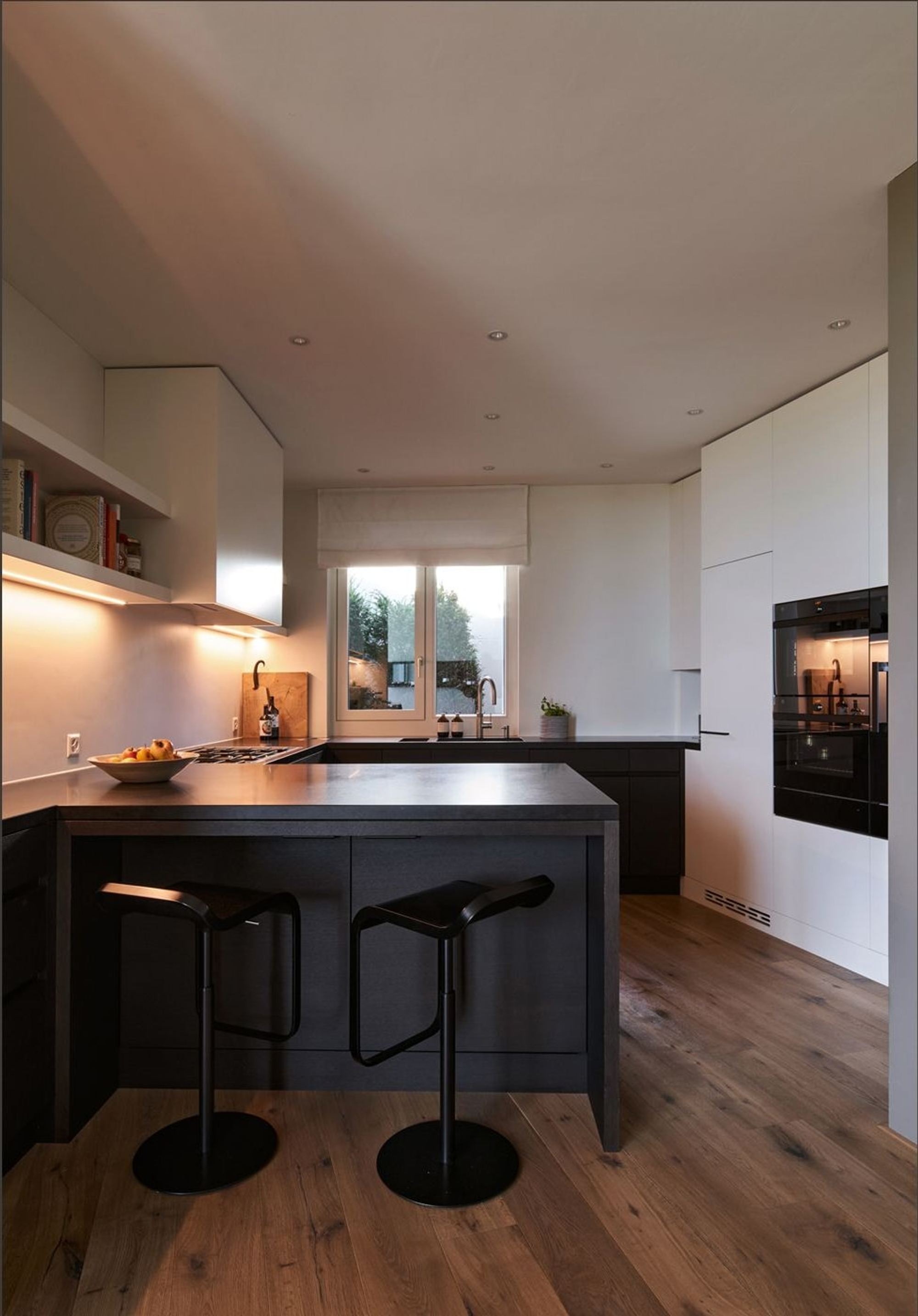 Kitchen with dark island and bar stools – Interiors and landscape, Lufingen