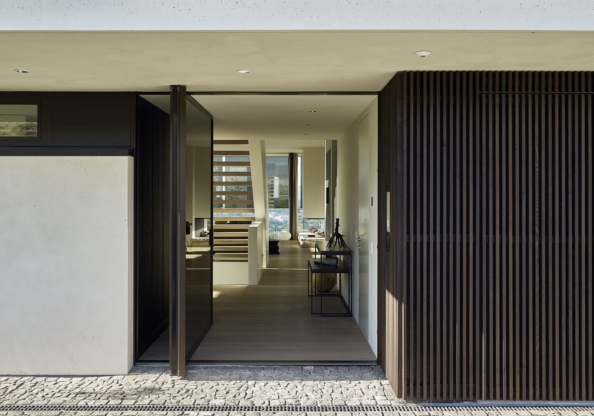 Entrance with timber slats and view to the staircase – Single-family house in Uitikon