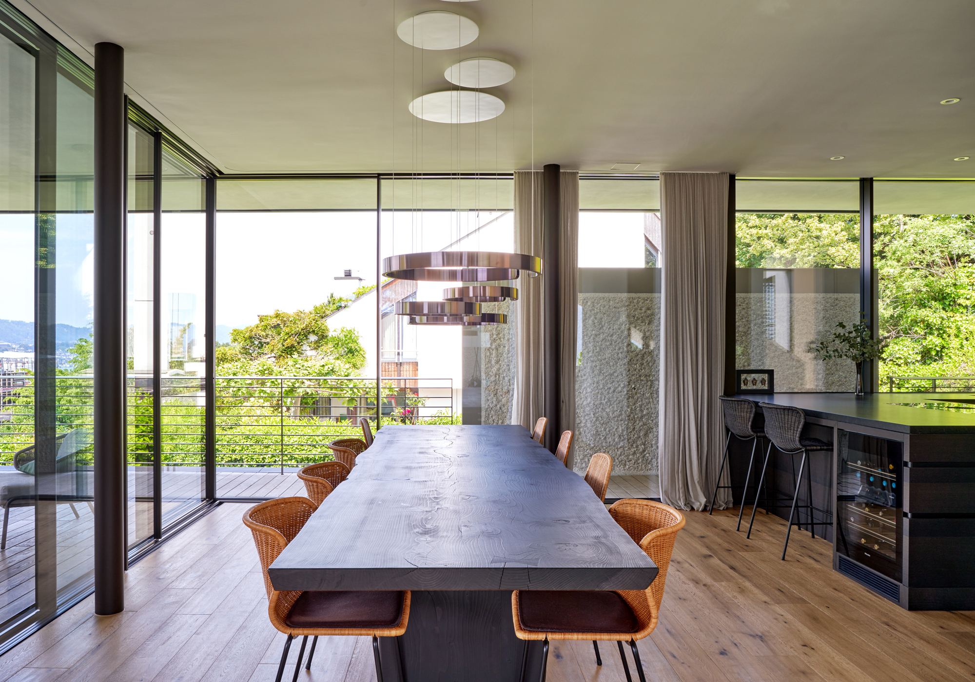 Dining area with long table and floor-to-ceiling glazing – Single-family house in Herrliberg