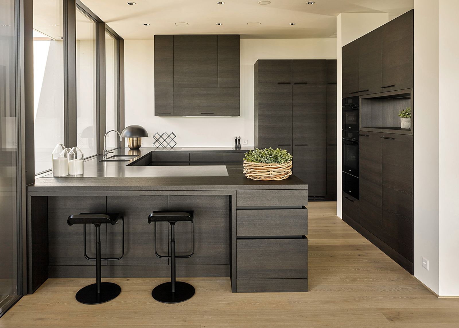 Kitchen with dark timber fronts and bar stools