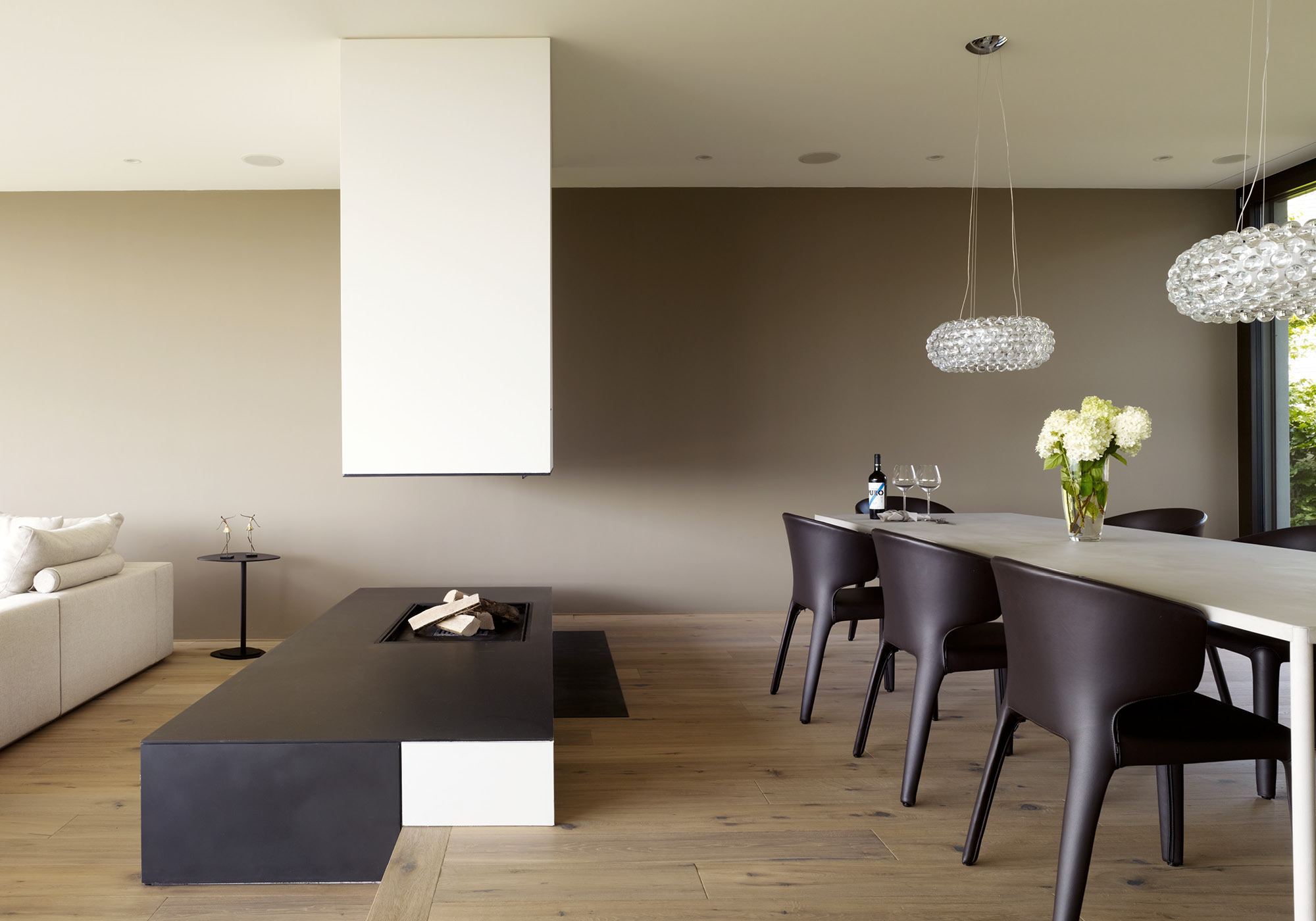 Dining area with pendant lights and fireplace – Single-family house in Oberwil-Lieli