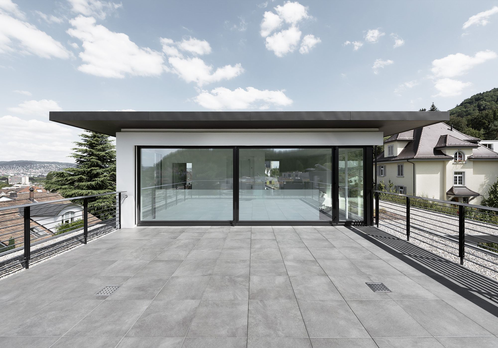 Roof terrace with stone paving and glass front – Single-family house in Zürich