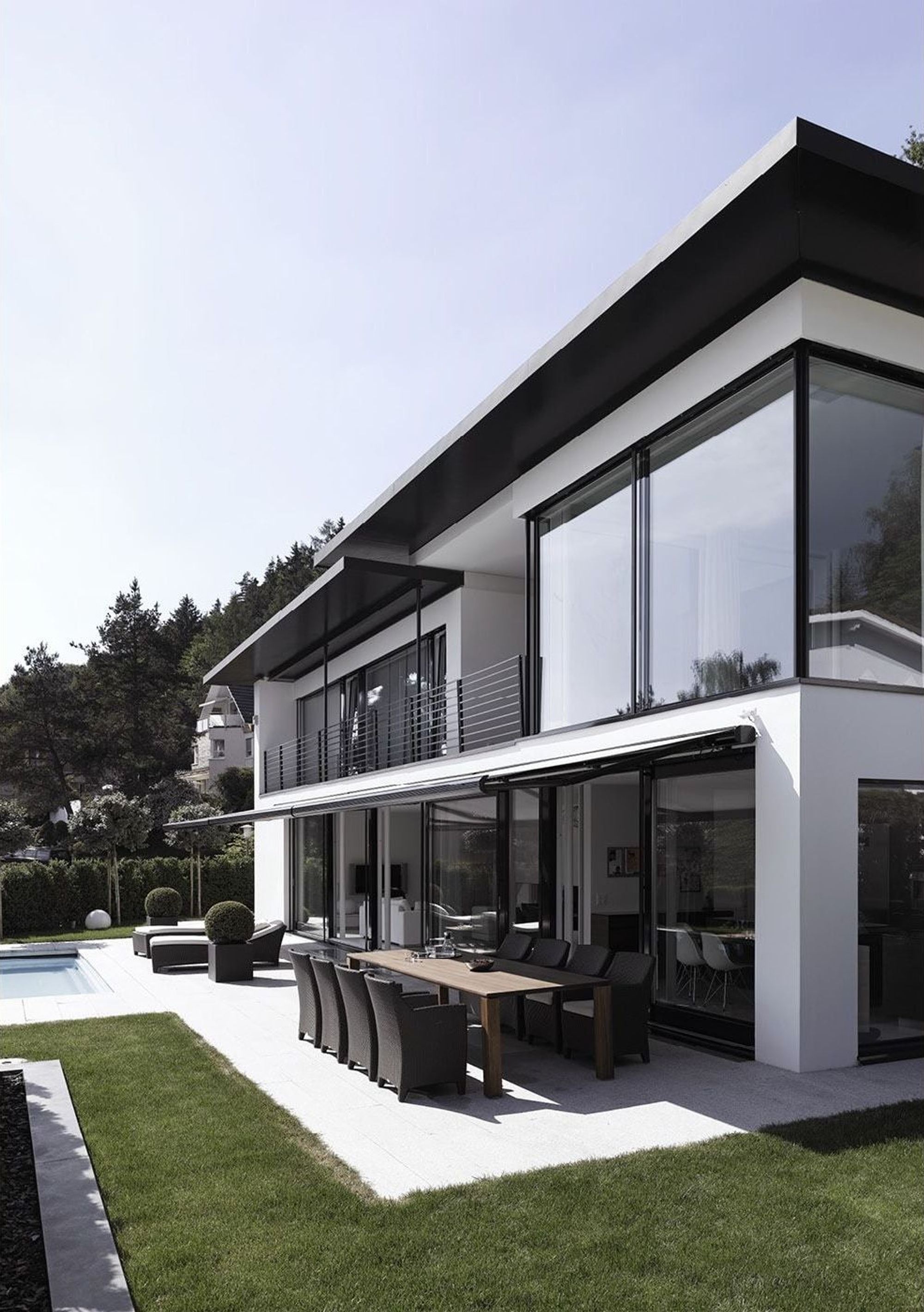 Facade with glass fronts and outdoor dining table – Single-family house in Geroldswil