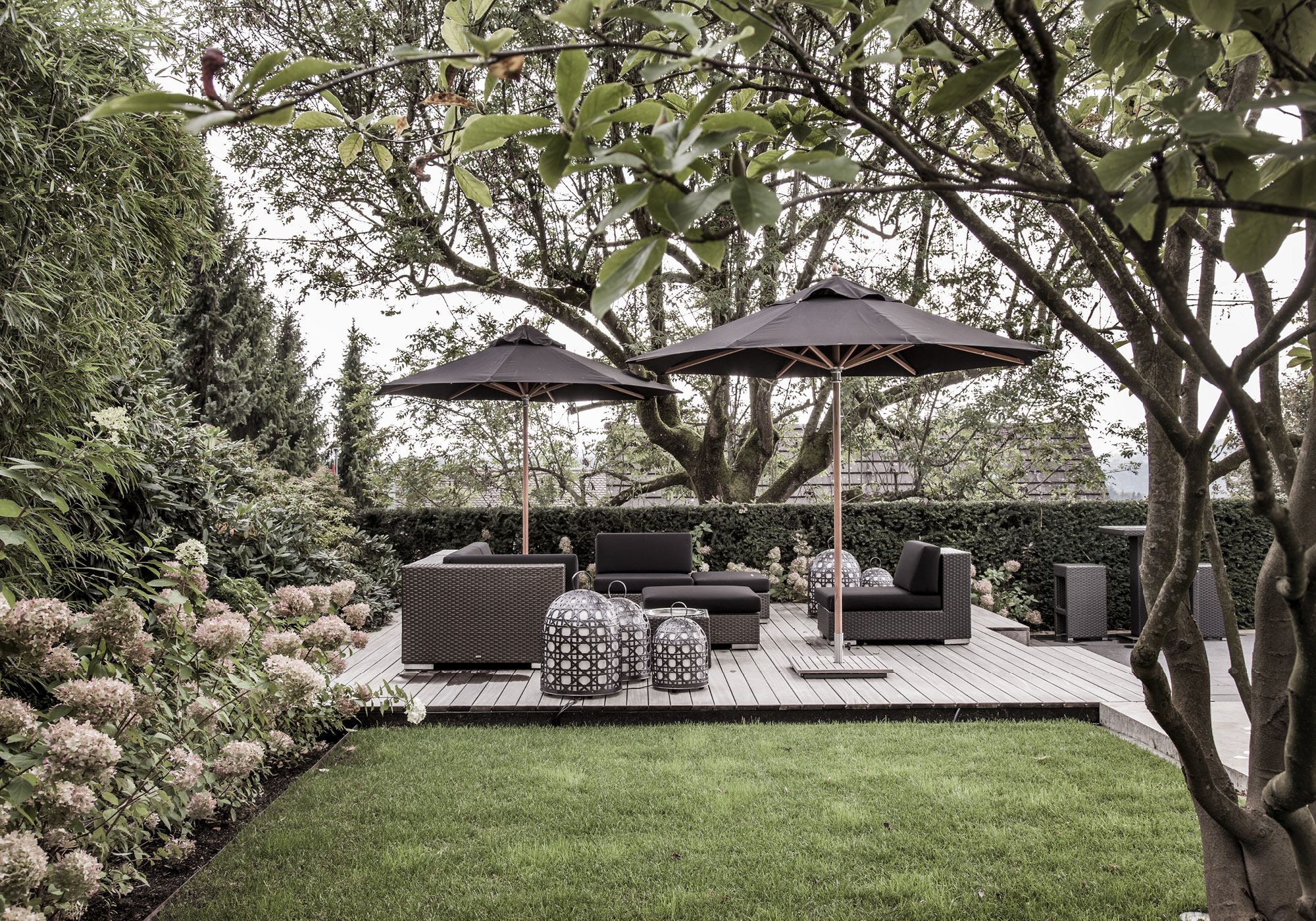 Lounge with parasols beneath mature trees – Single-family house in Uitikon