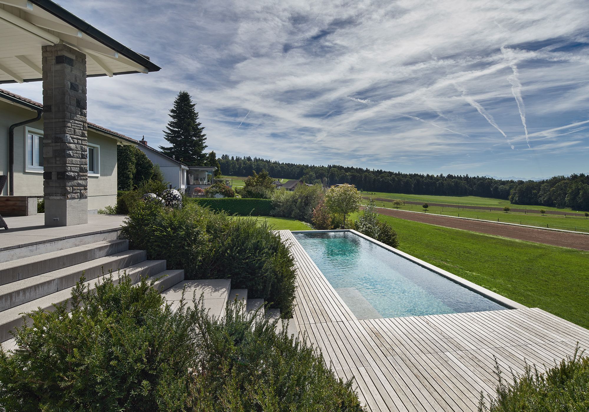 Pool with timber deck and view over the fields – Interiors and landscape, Lufingen