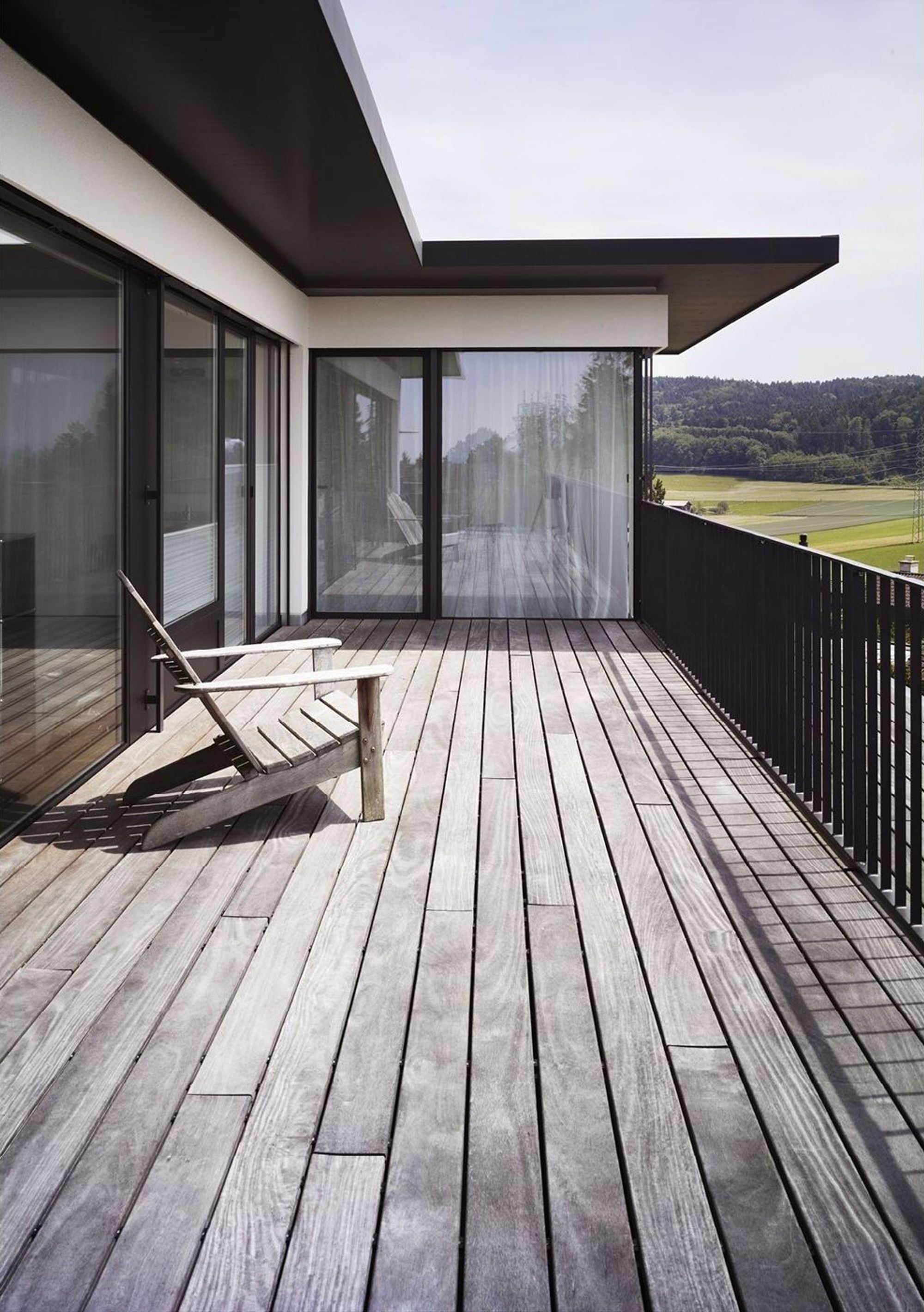 Balcony with timber floor and deckchair – Single-family house in Russikon