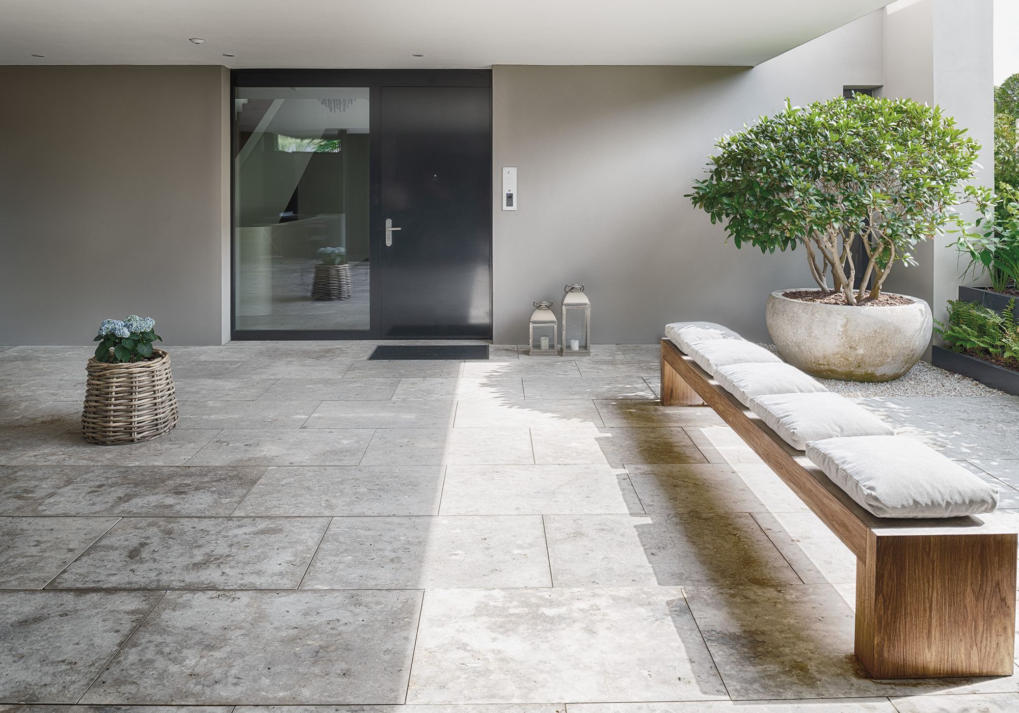 Entrance with timber bench and plant pot – Single-family house in Schindellegi
