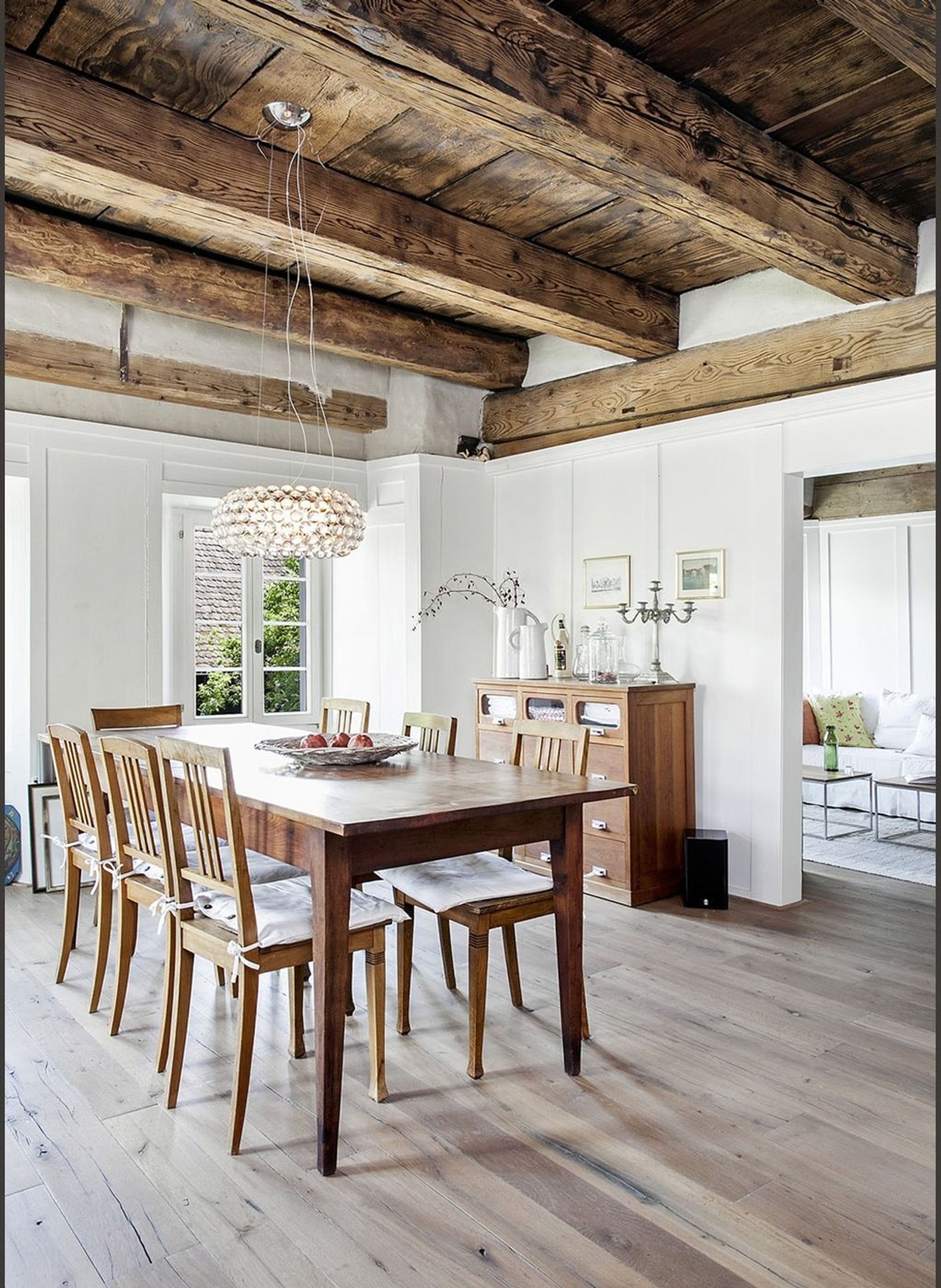 Timber dining table beneath the beam ceiling – Historic conversion in Uerikon