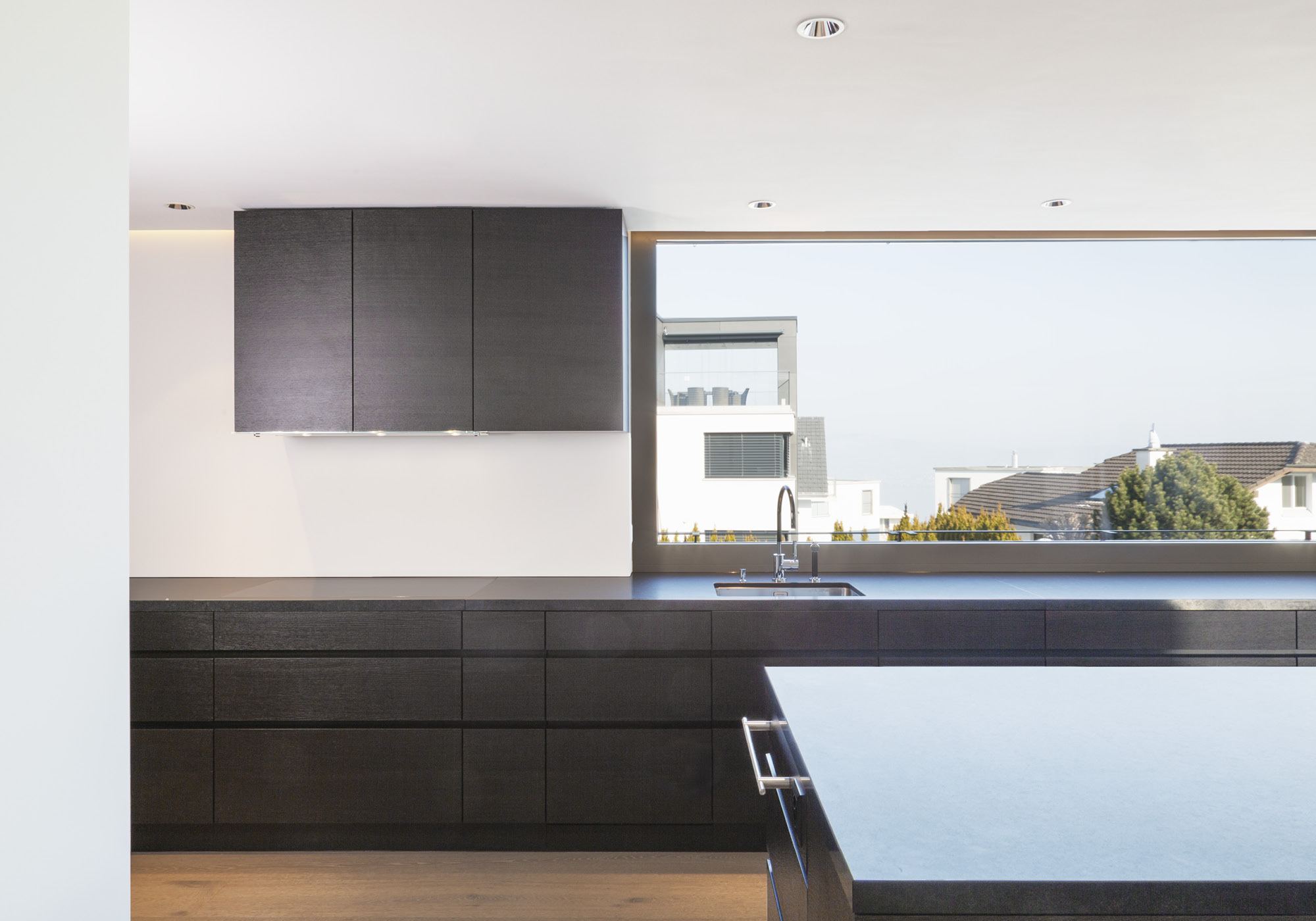 Kitchen run with wall cabinets in front of the window – Single-family house in Wollerau