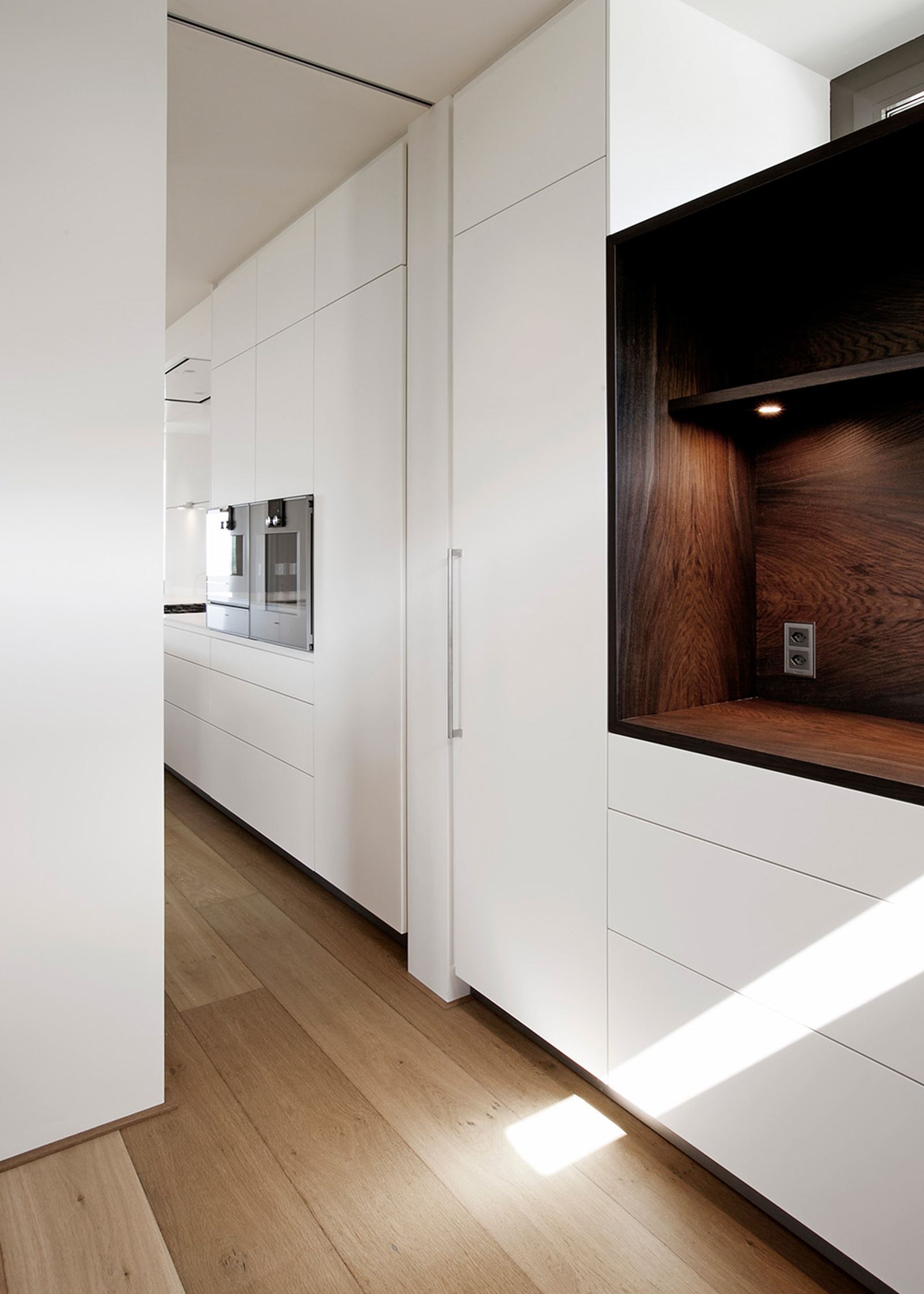 White tall cabinets with timber niche
