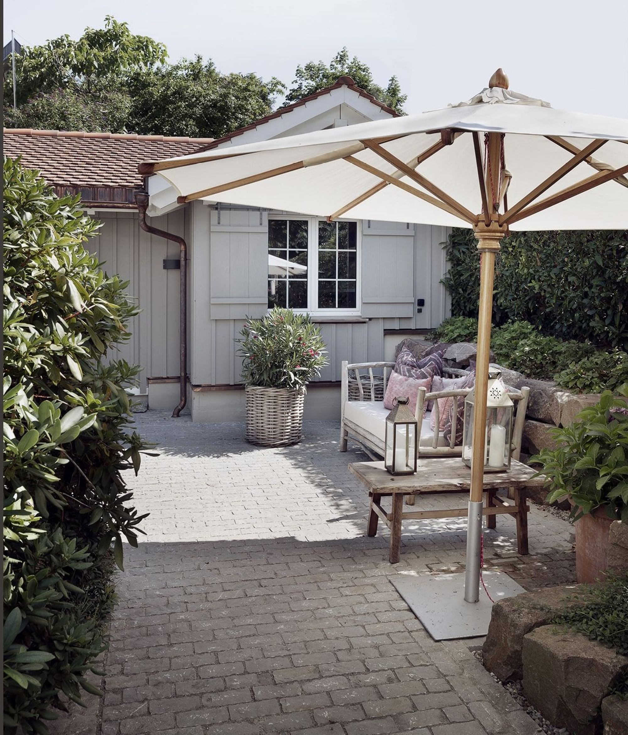 Seating area with parasol by the garden house – Single-family house in Uitikon