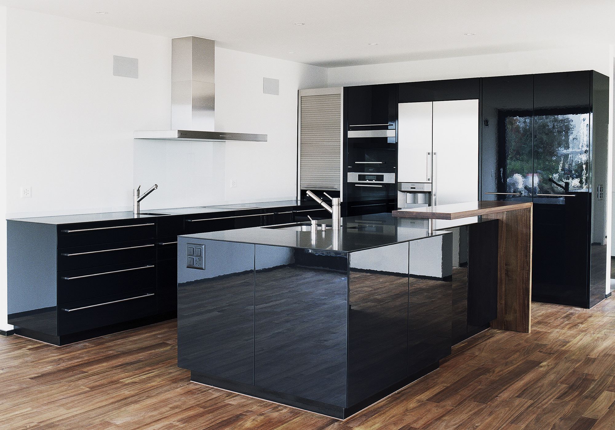 Kitchen with black high-gloss island – Apartment building in Uitikon