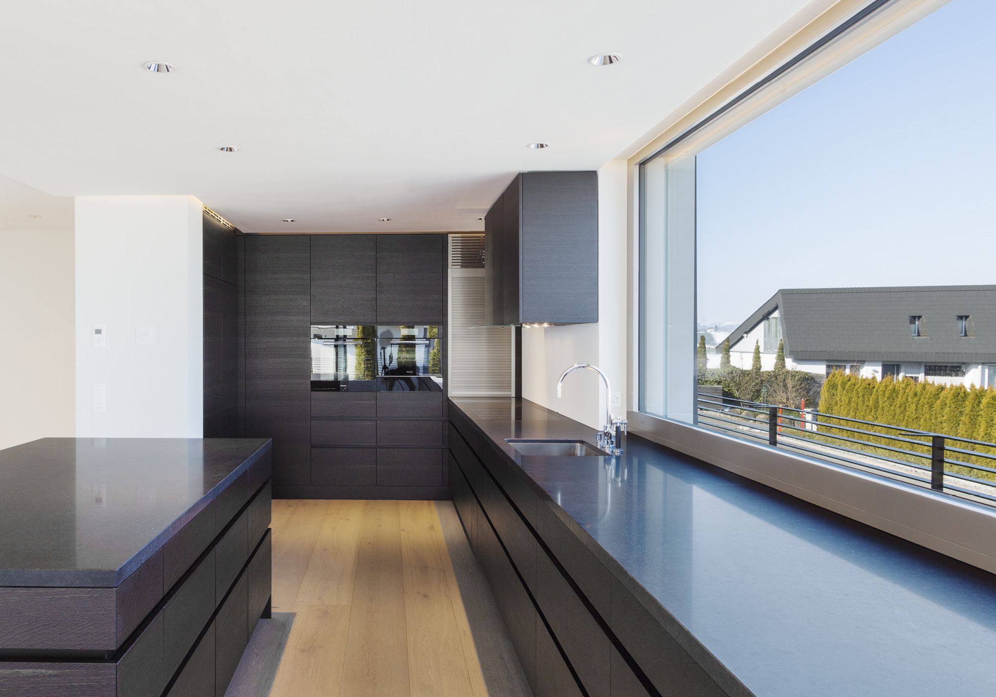 Kitchen with dark fronts and large window – Single-family house in Wollerau