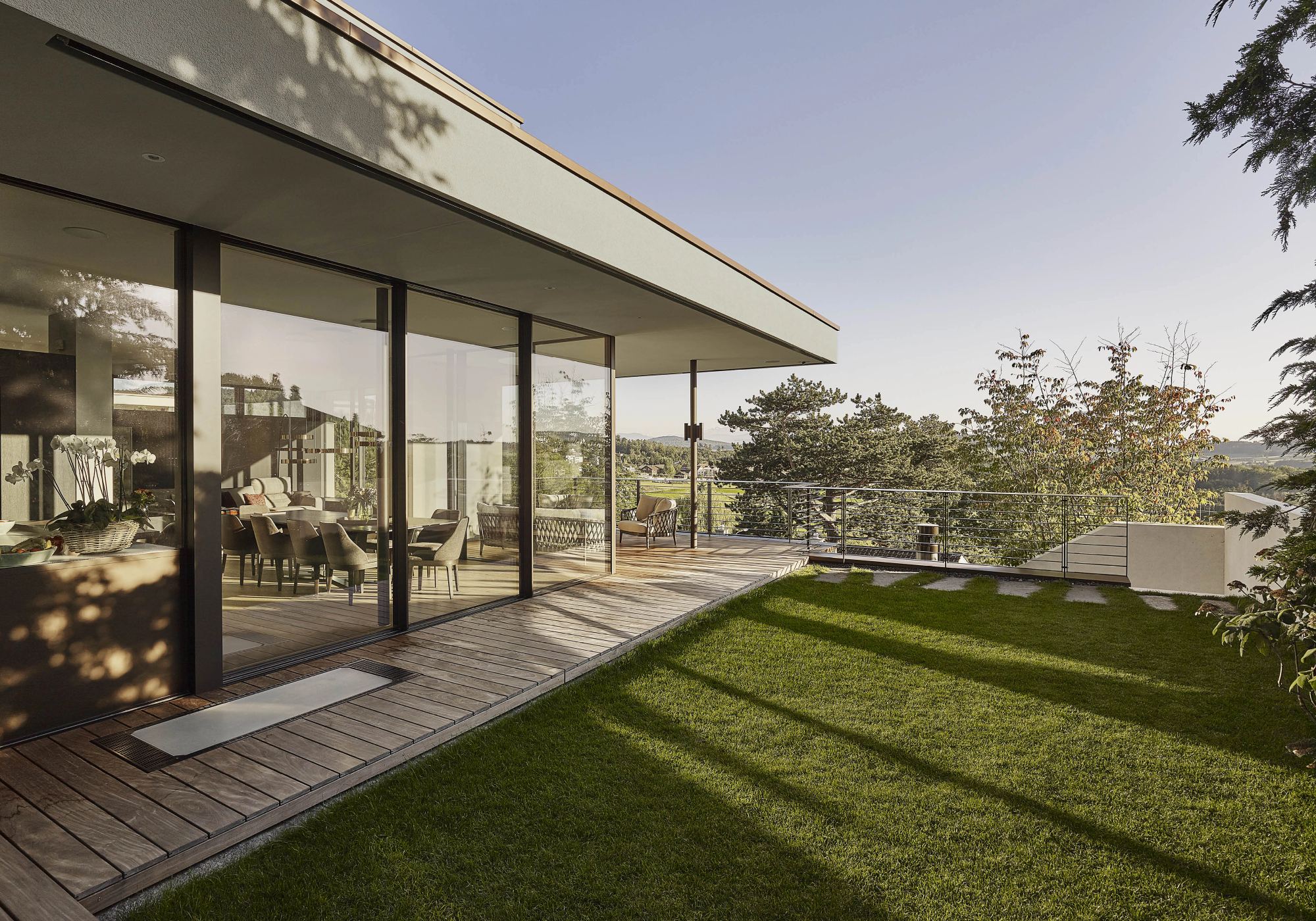 Covered seating area with timber floor and lawn – Single-family house in Uitikon