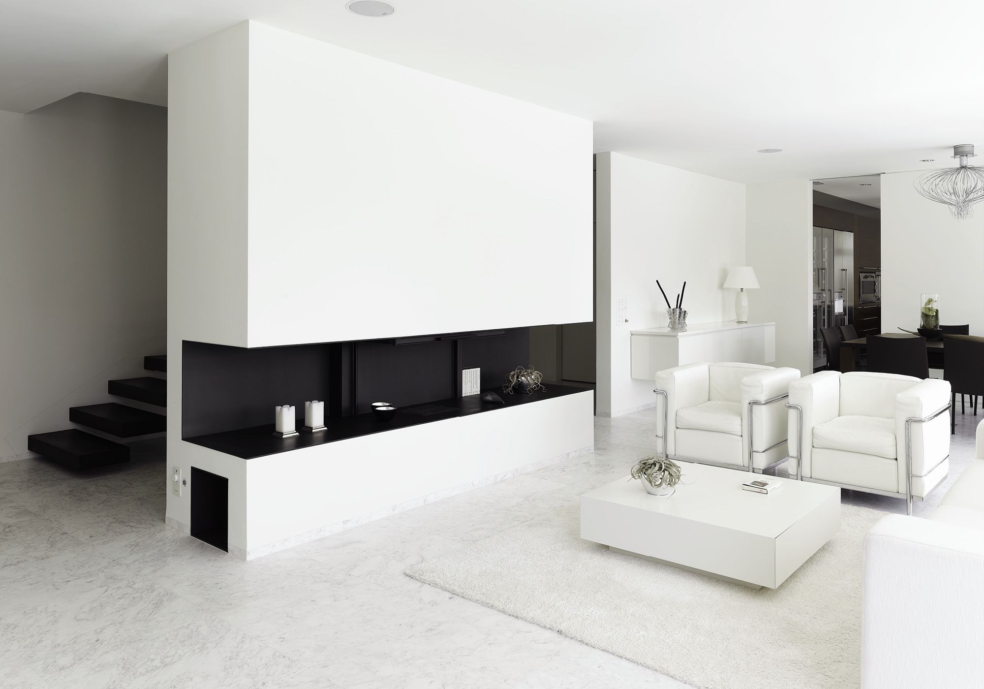 White living space with fireplace and armchairs – Single-family house in Geroldswil