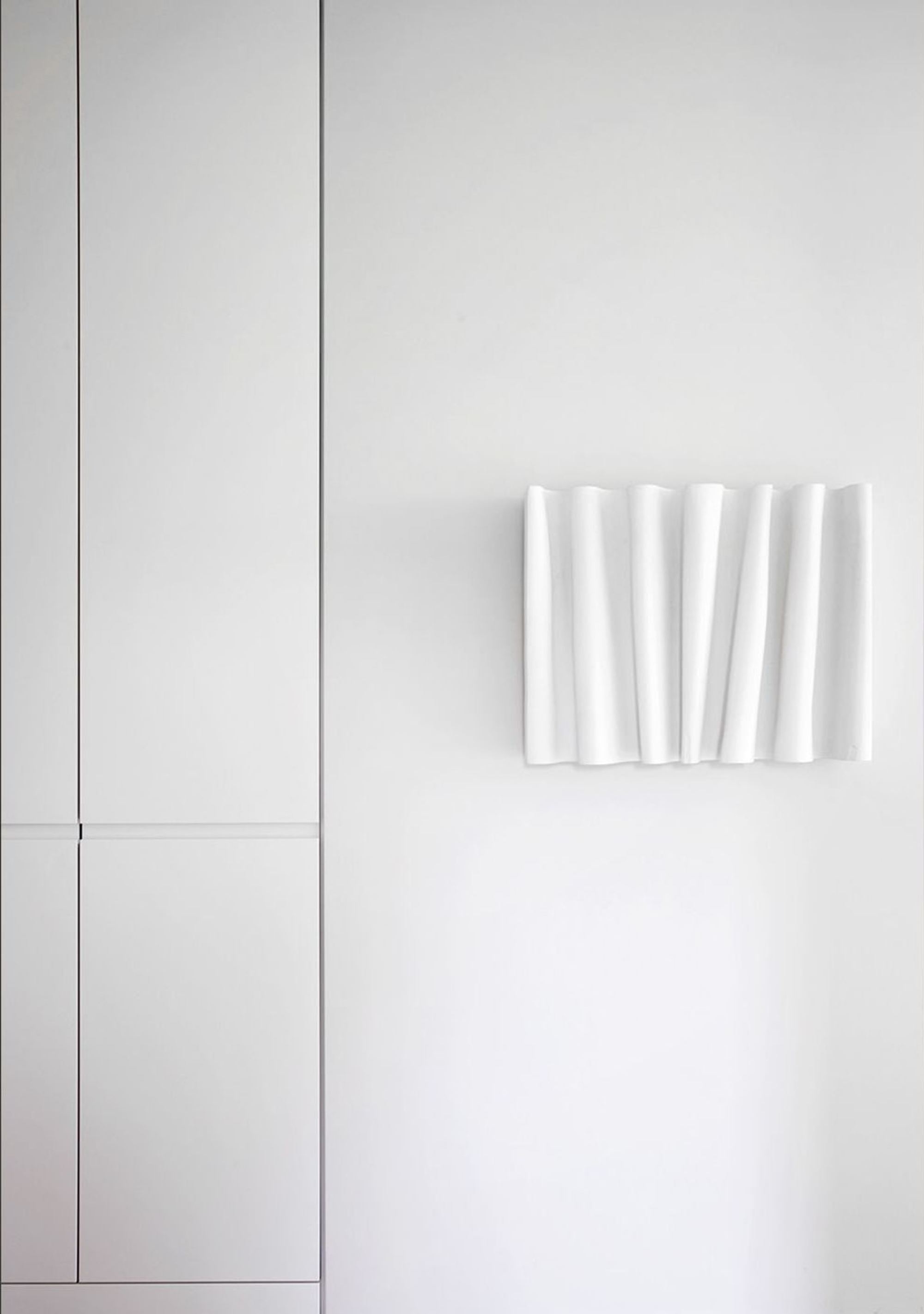 White wall with sculptural wall piece – Apartment building in Uitikon