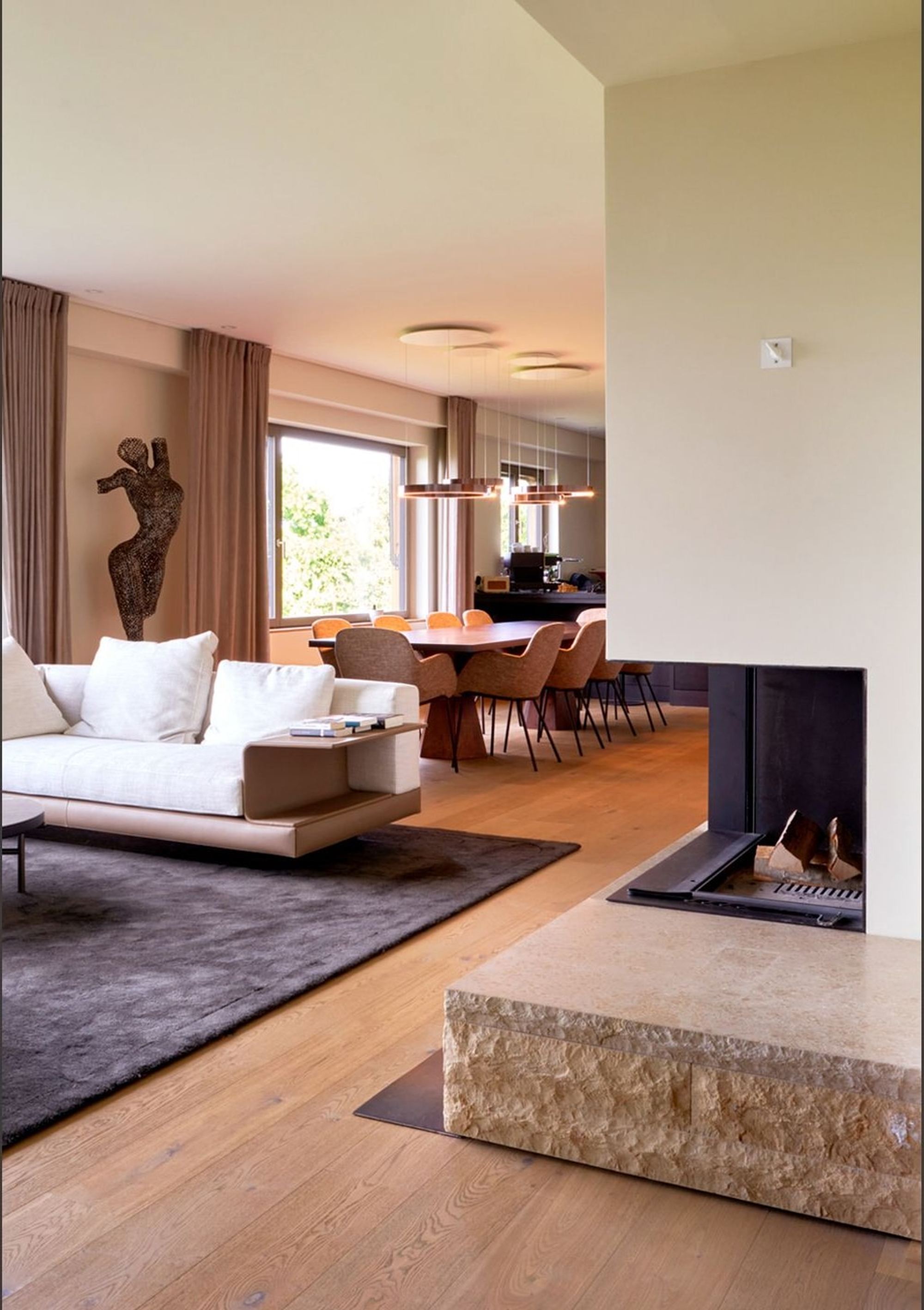 Living area with fireplace and view through to the dining area – Interiors and landscape, Meilen