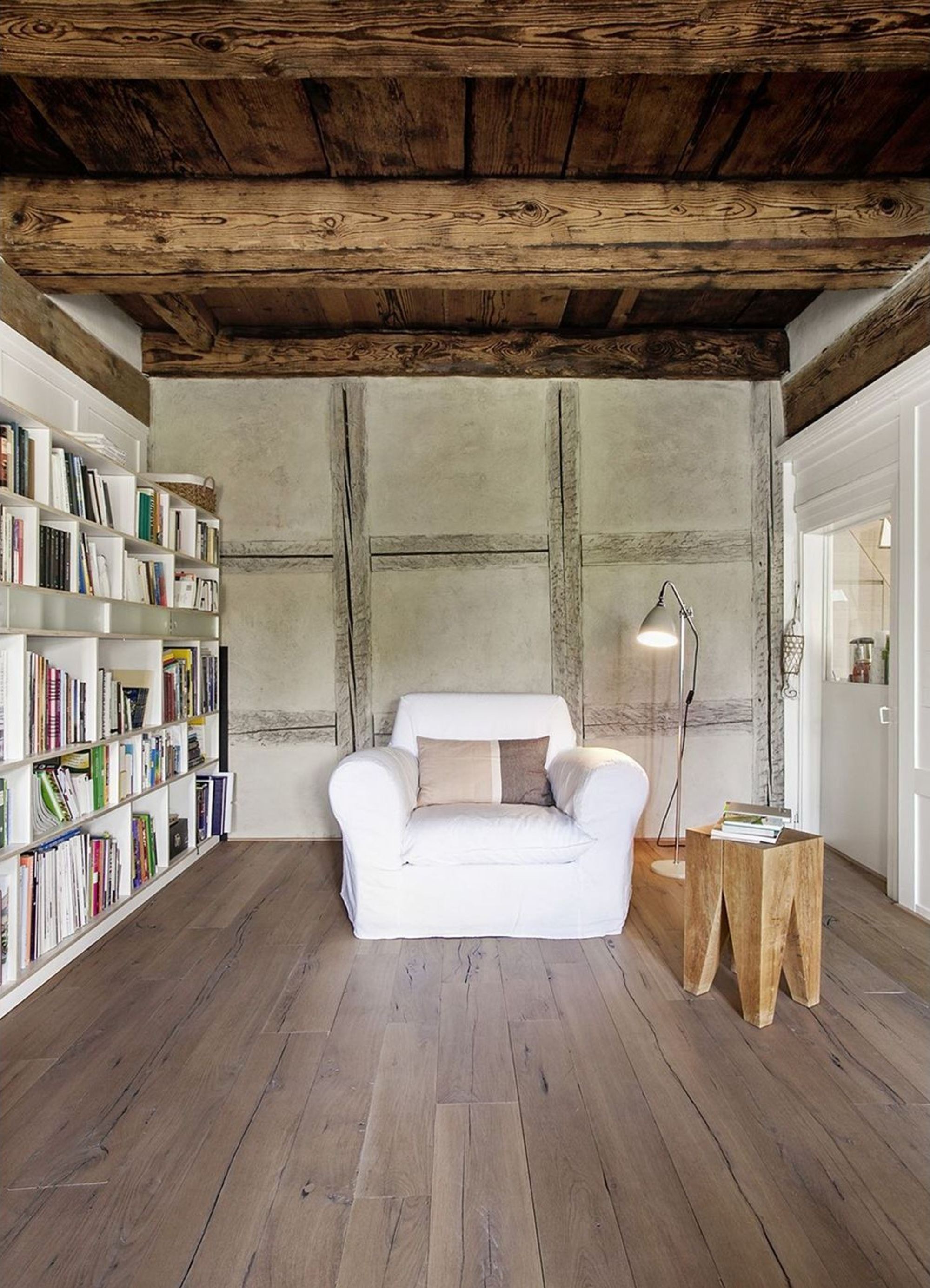 Leseecke mit Sessel, Bücherwand und Riegelwand – Historischer Umbau in Uerikon