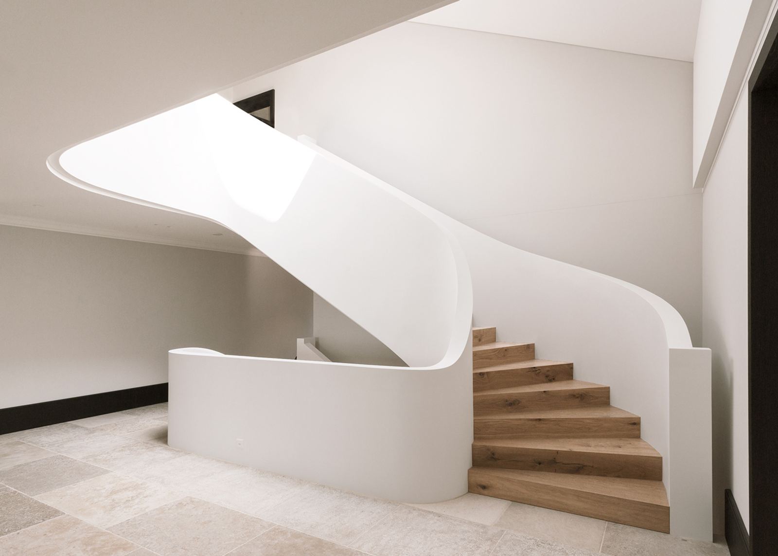 Winding staircase with timber treads and white stringer