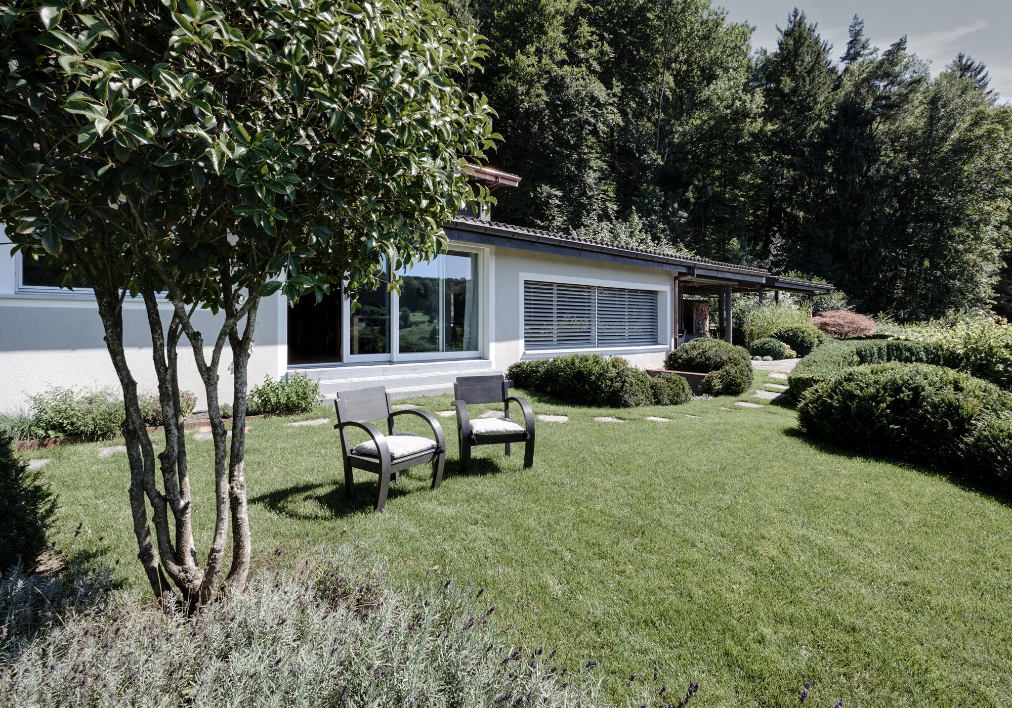 Garden with armchairs, rounded shrubs and a tree – Interiors and landscape, Stallikon
