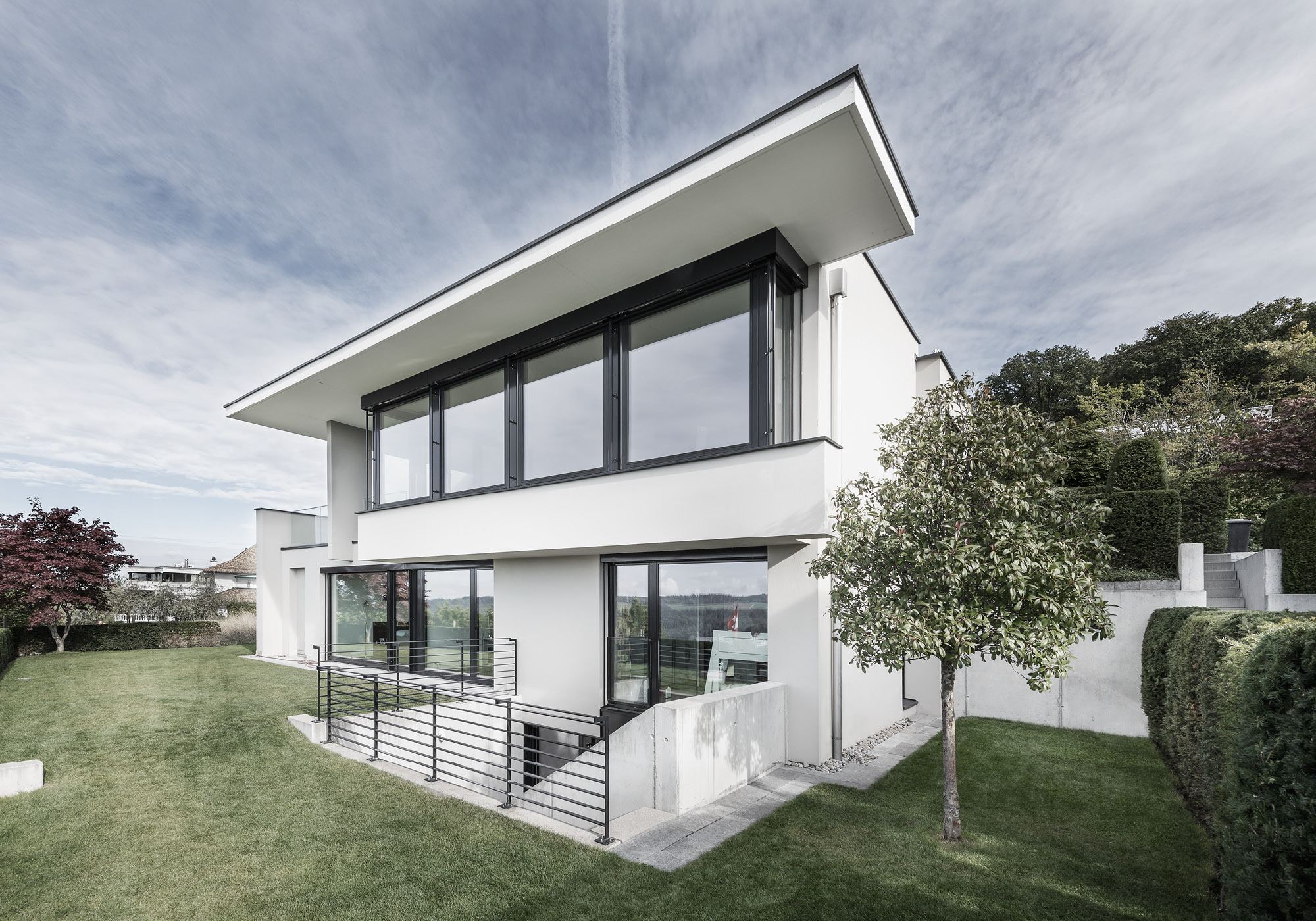 White house with cantilevered roof and ribbon window – Single-family house in Uitikon