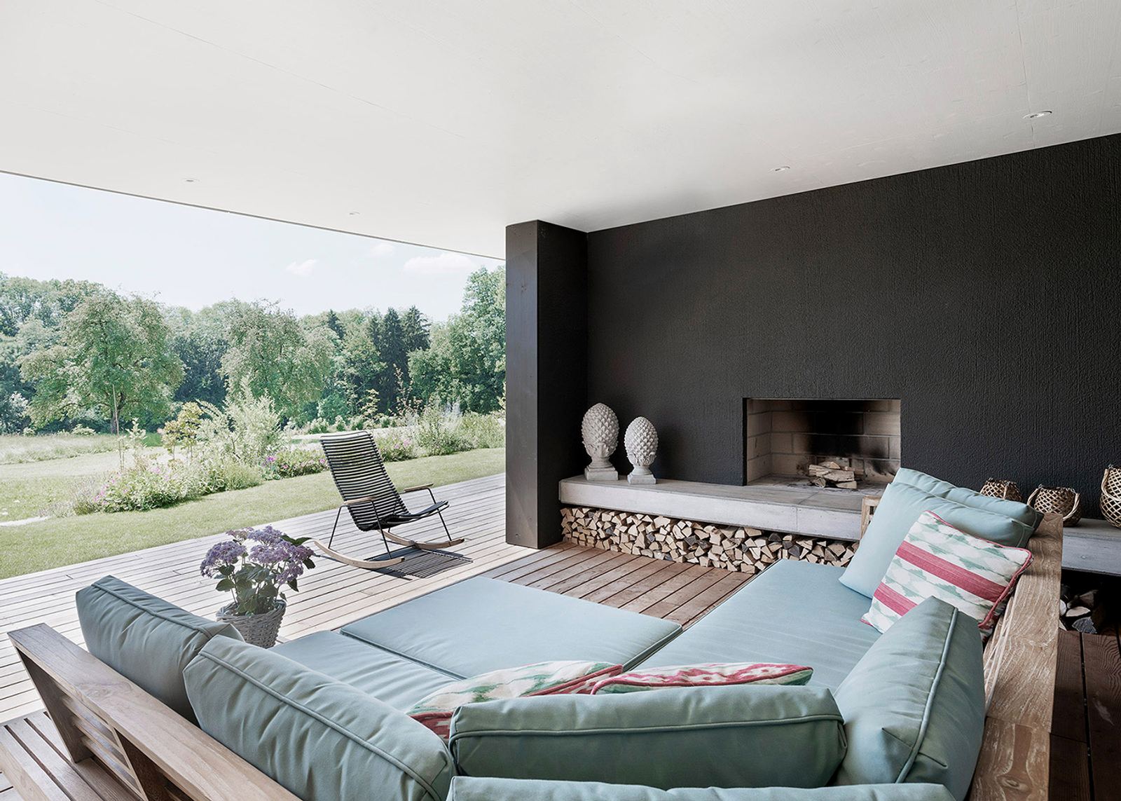 Outdoor lounge with fireplace and firewood