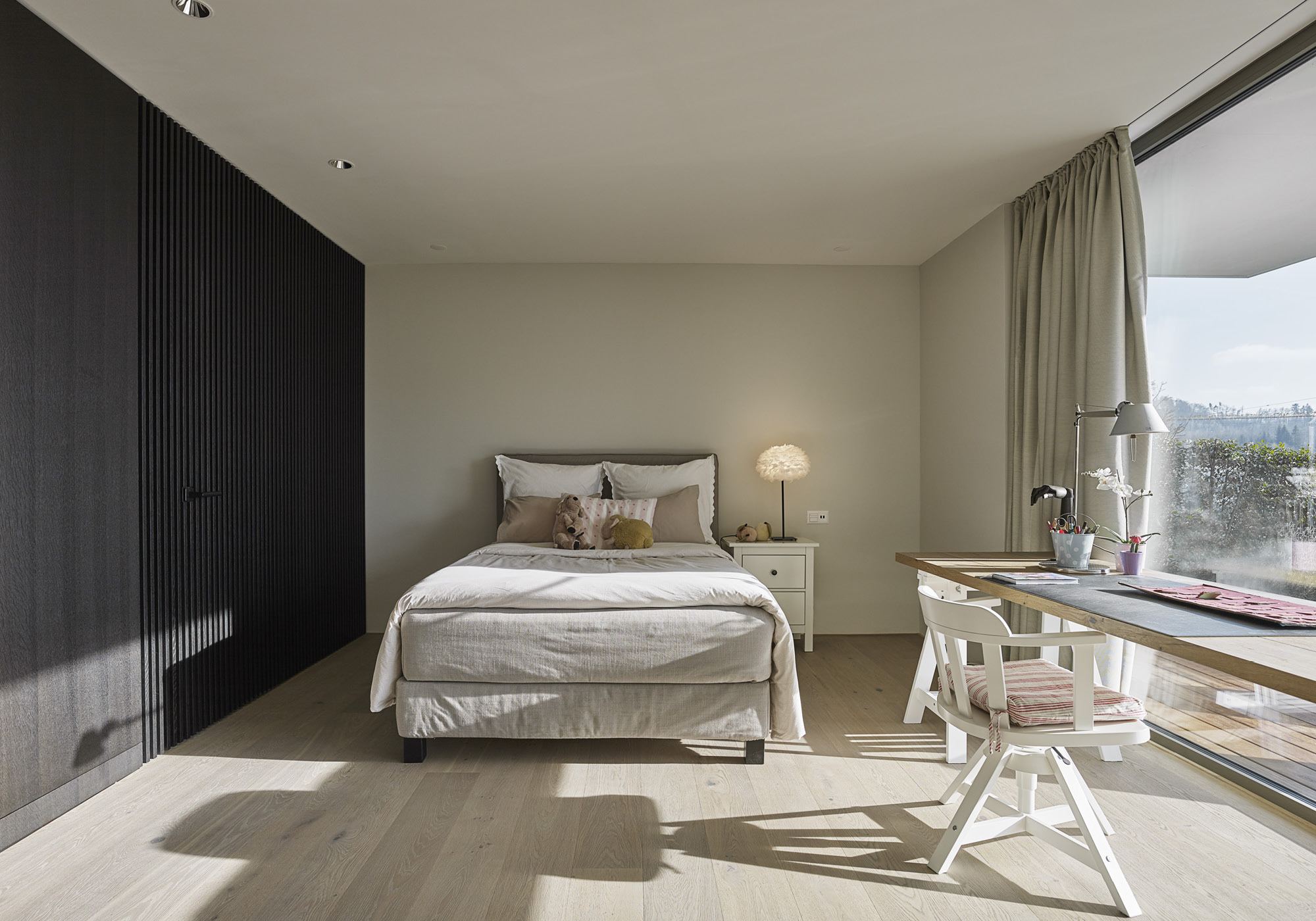 Guest room with desk and window front – Single-family house in Uitikon
