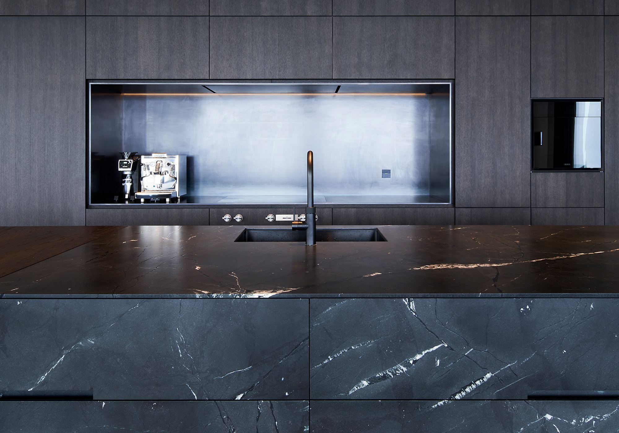 Kitchen wall with niche and dark marble worktop – Single-family house in Schindellegi