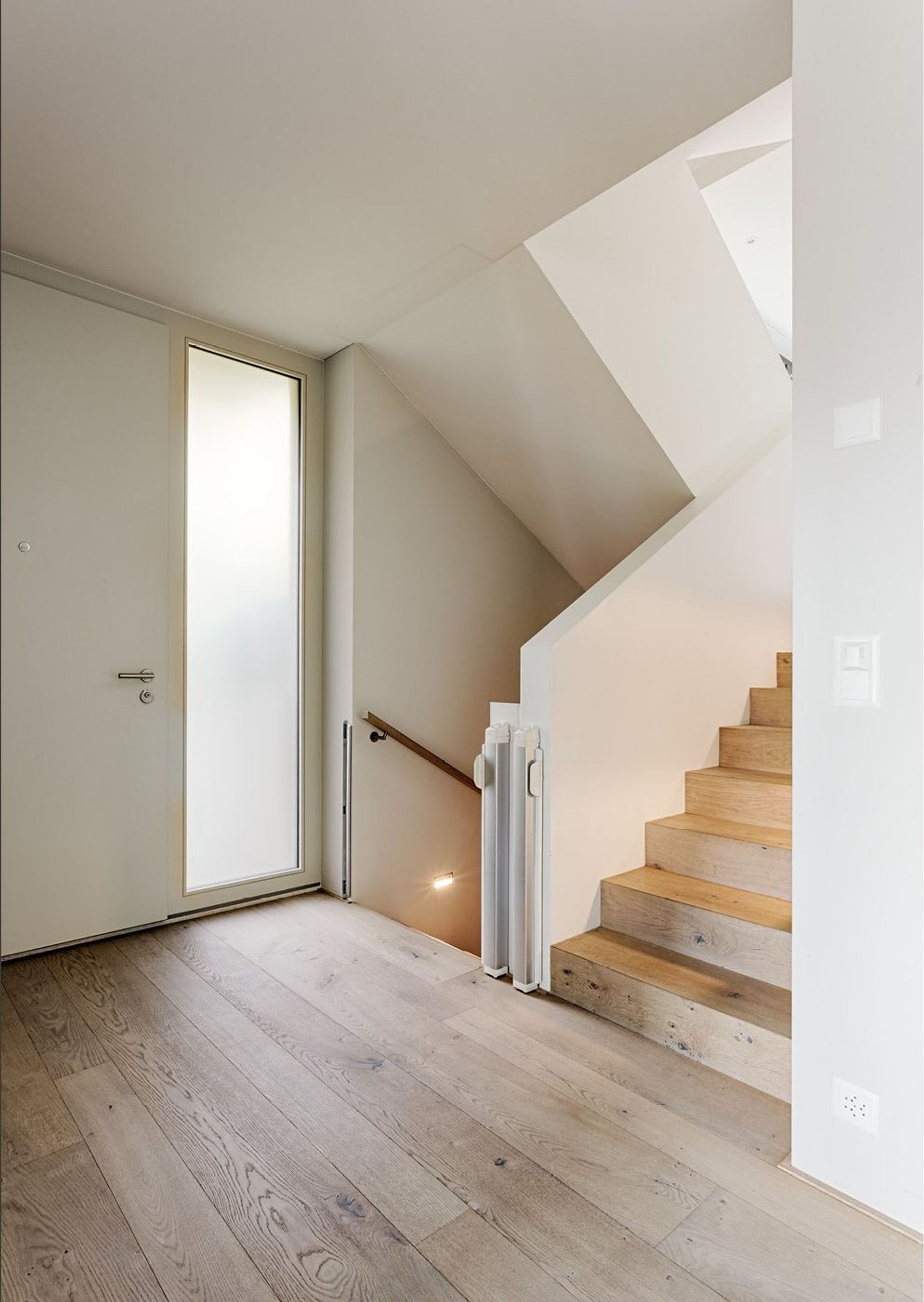 Staircase with timber treads and narrow window – Single-family house in Zürich