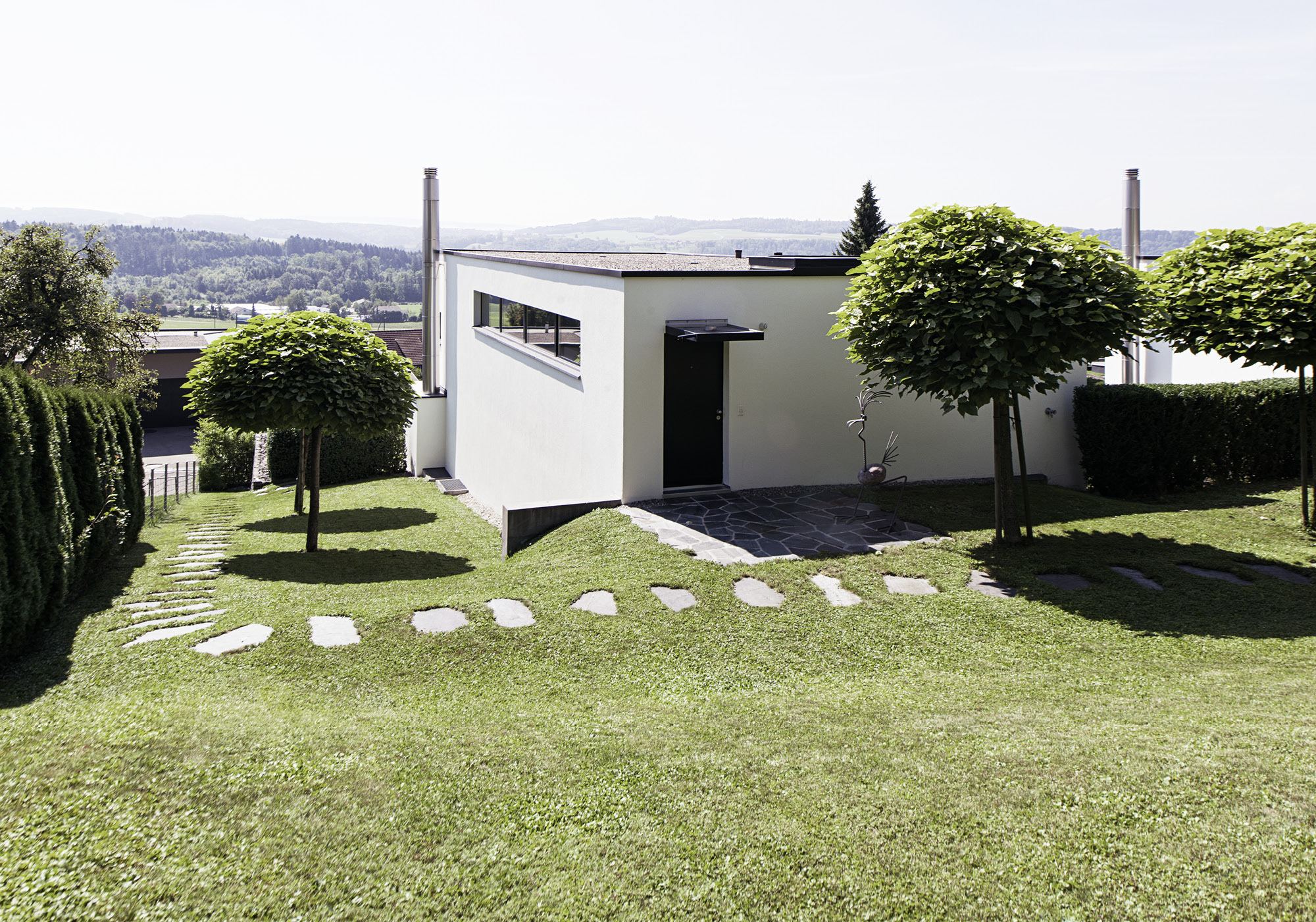 Garden with stepping stones and globe trees – Single-family house in Uitikon