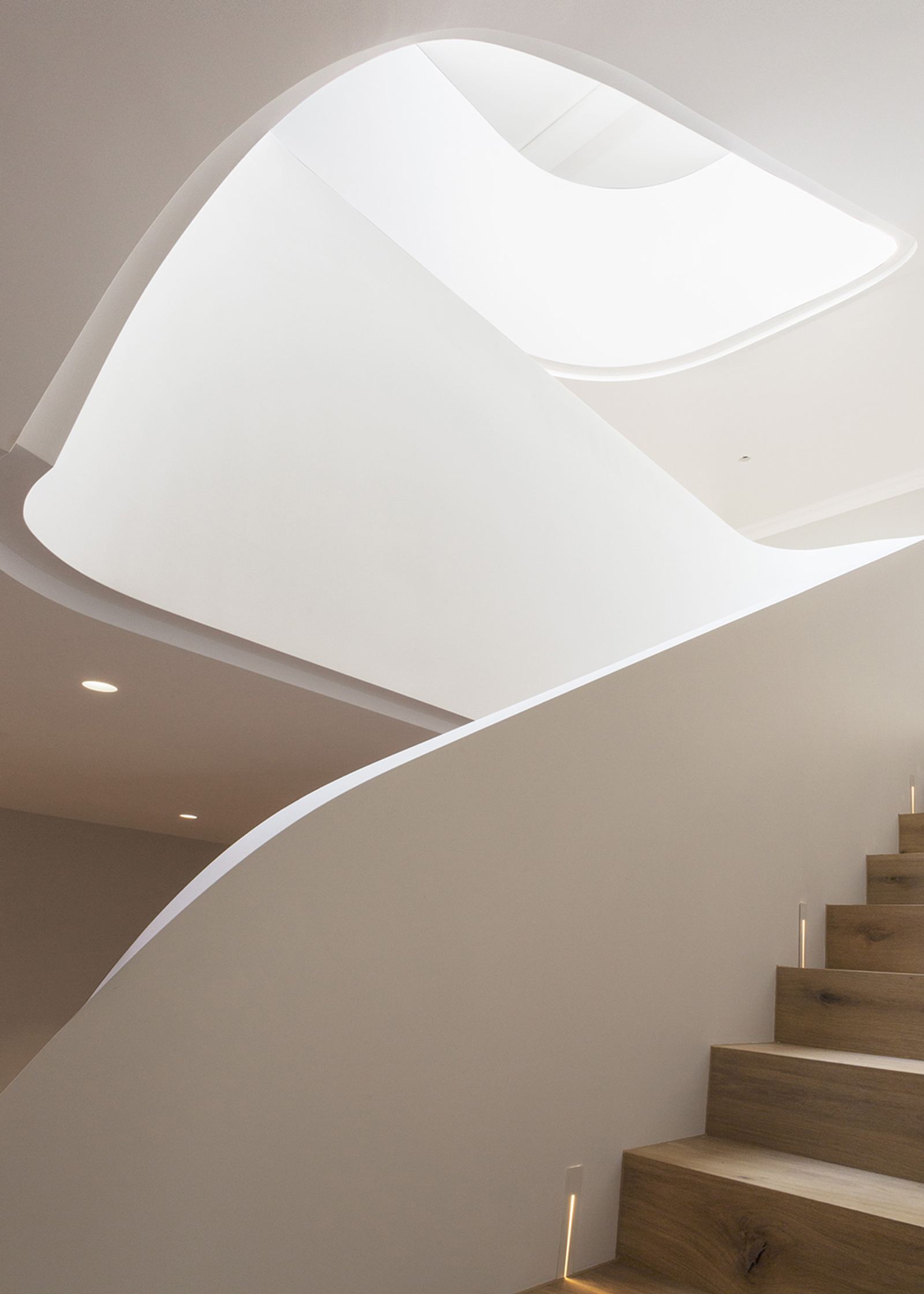 White spiral staircase with timber treads from below