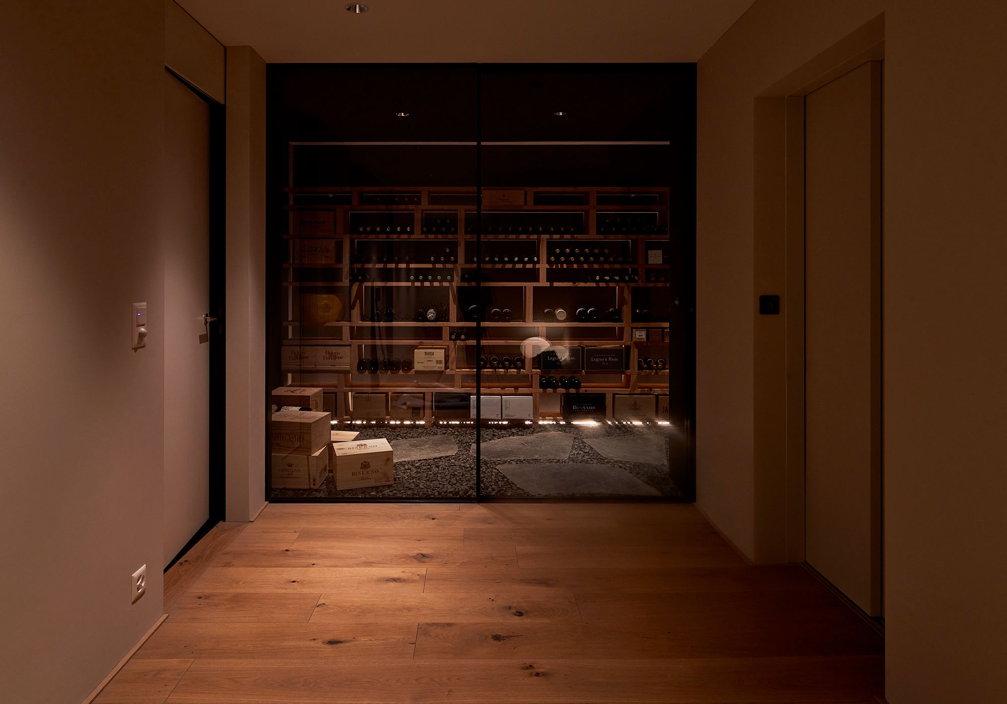 Wine cellar behind a glass door at the end of the hallway – Single-family house in Uitikon