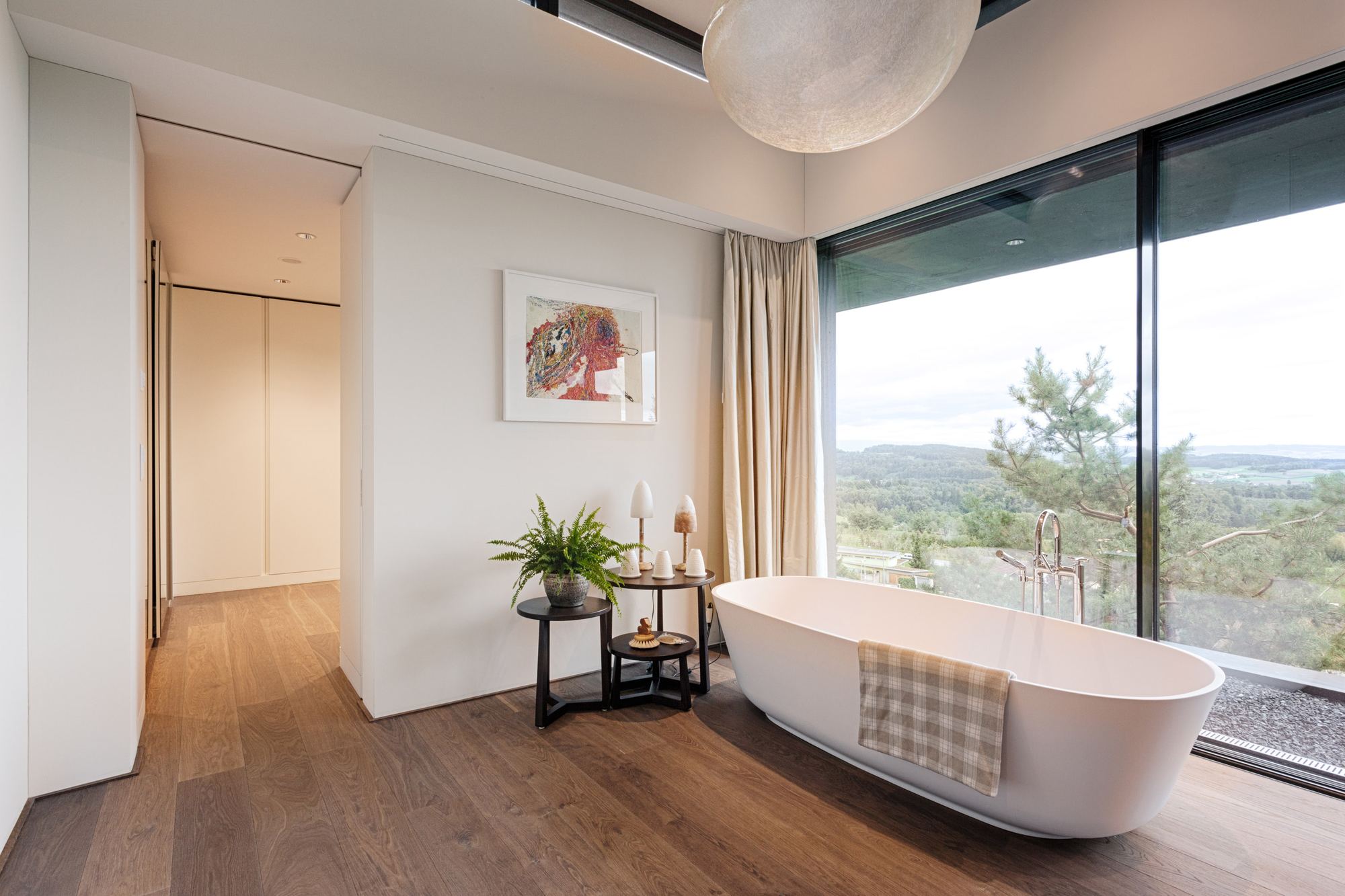 Bathroom with freestanding bath and panoramic window – Single-family house in Uitikon