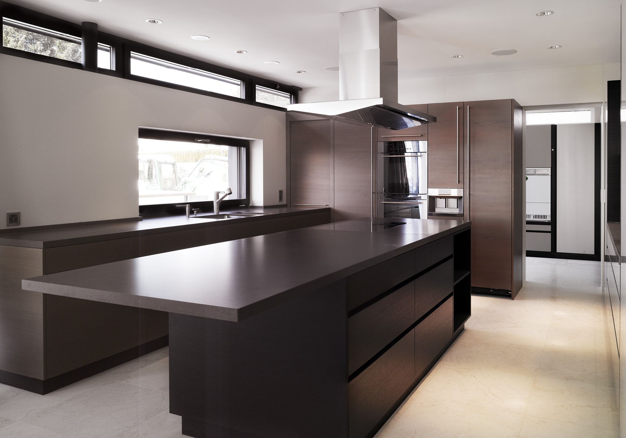 Dark kitchen with island and extractor hood – Single-family house in Uitikon