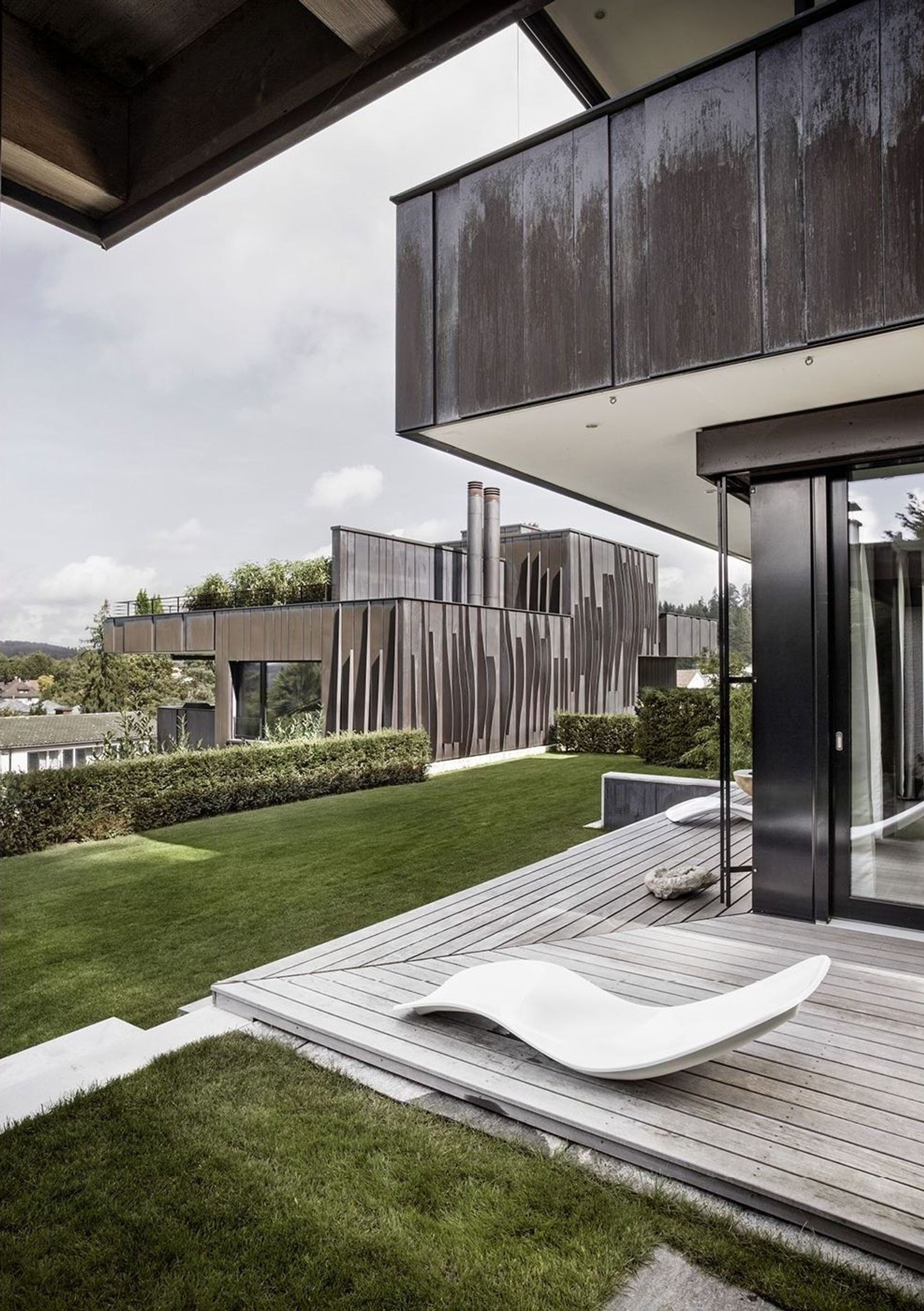 Timber deck with lounger under the canopy – Apartment building in Uitikon