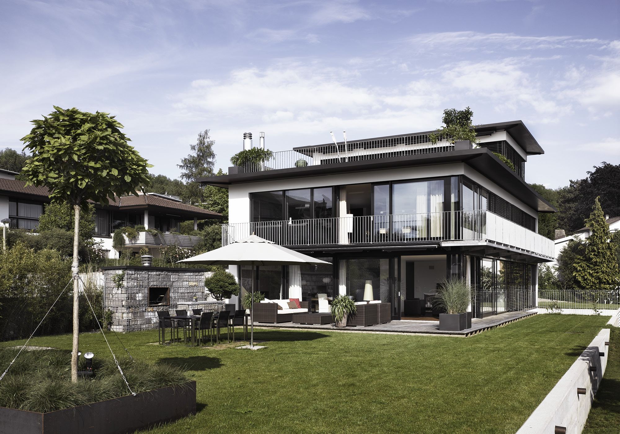 Garden side with seating area and green roof – Apartment building in Uitikon